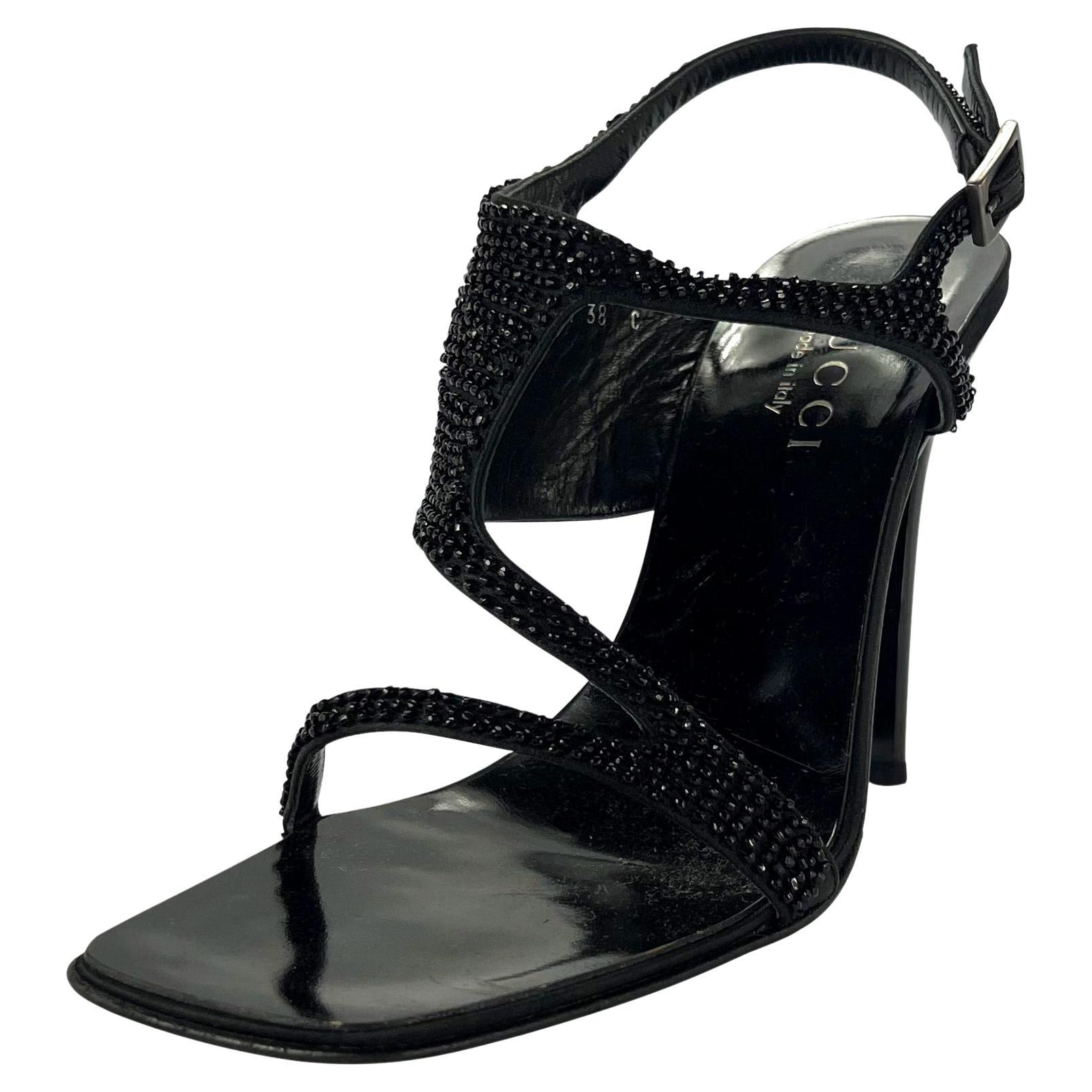 Presenting a pair of black beaded Gucci heels, designed by Tom Ford. From the early 2000s, this incredible pair of sleek black heels feature straps covered in black caviar beads with an adorning silver-tone buckle at the ankle. The perfect pair of