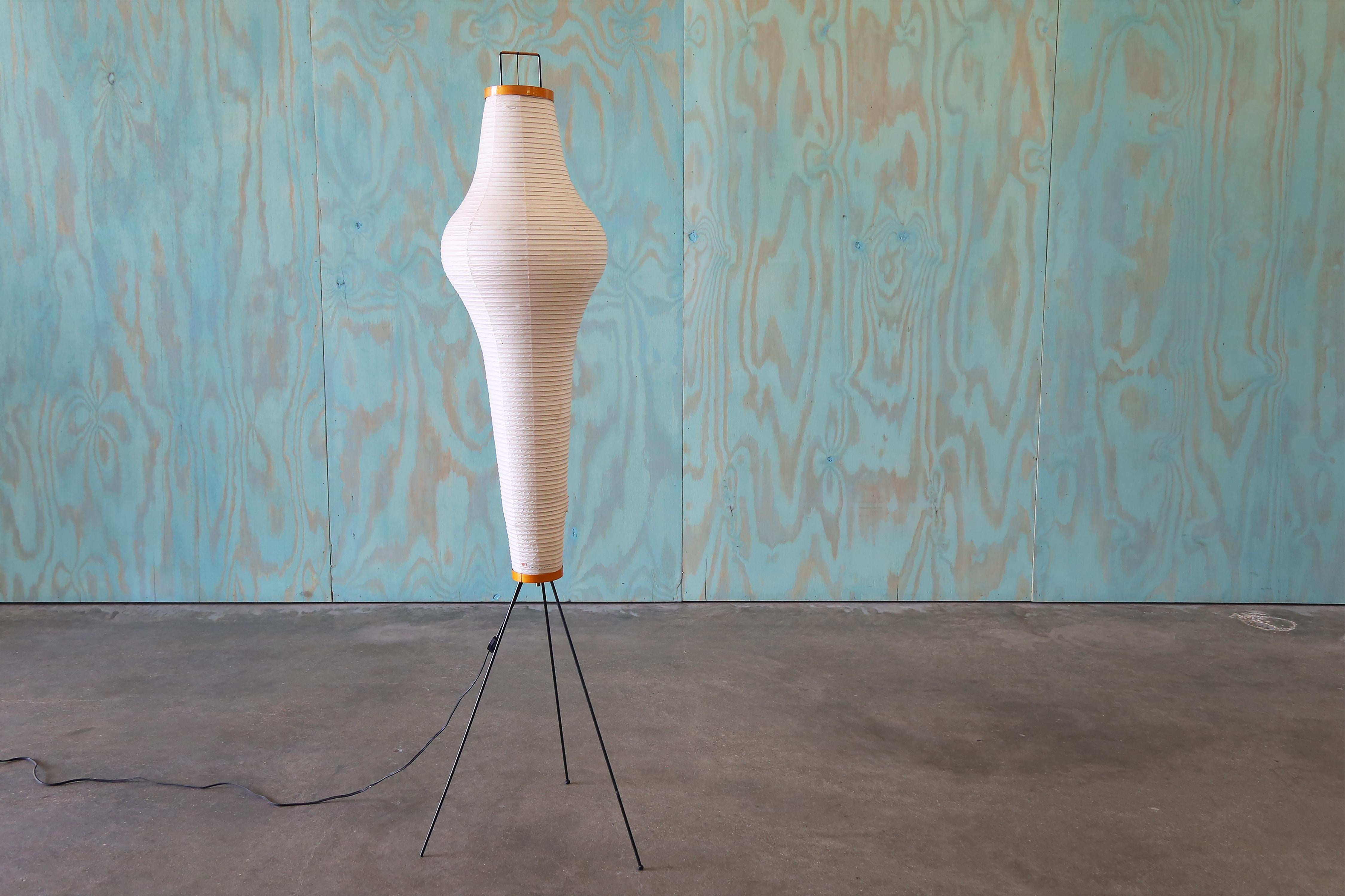 Iconic Isamu Noguchi Floor lamp, model 14a for Akari. Electric works.

Signed.

Dimensions: 
63” Height 16.5” Width
Shade 13” Diameter

Condition: Tear at bottom of lamp shade with light blemishes throughout. Missing a rubber foot. Electrical
