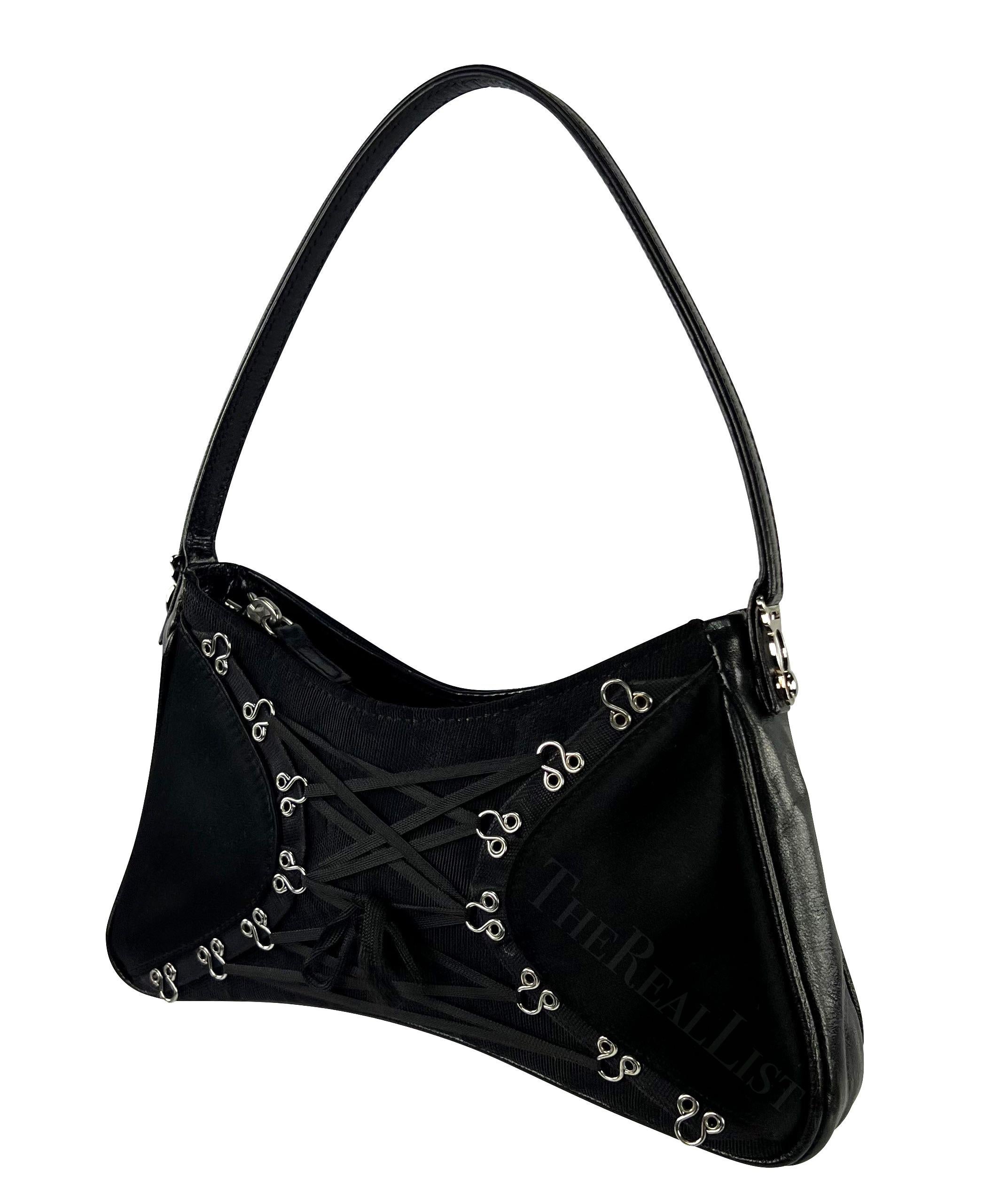 Presenting a stunning black satin John Galliano lace mini bag. A timeless piece from the early 2000s. This exquisite creation features a sleek black satin body adorned with luxurious black leather finishes. The silver-tone hardware, eyelets, and