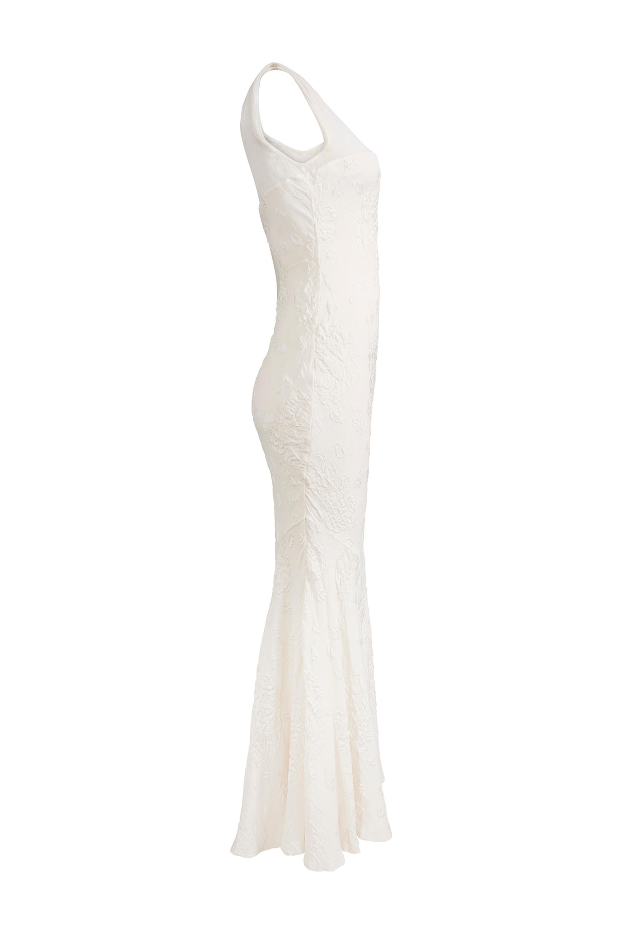 This early 2000's bridal gown is by acclaimed British designer John Galliano and is in excellent vintage condition. The white silk fabric is embossed with a tiny herringbone pattern which features as a subtle background texture. The beautiful rose