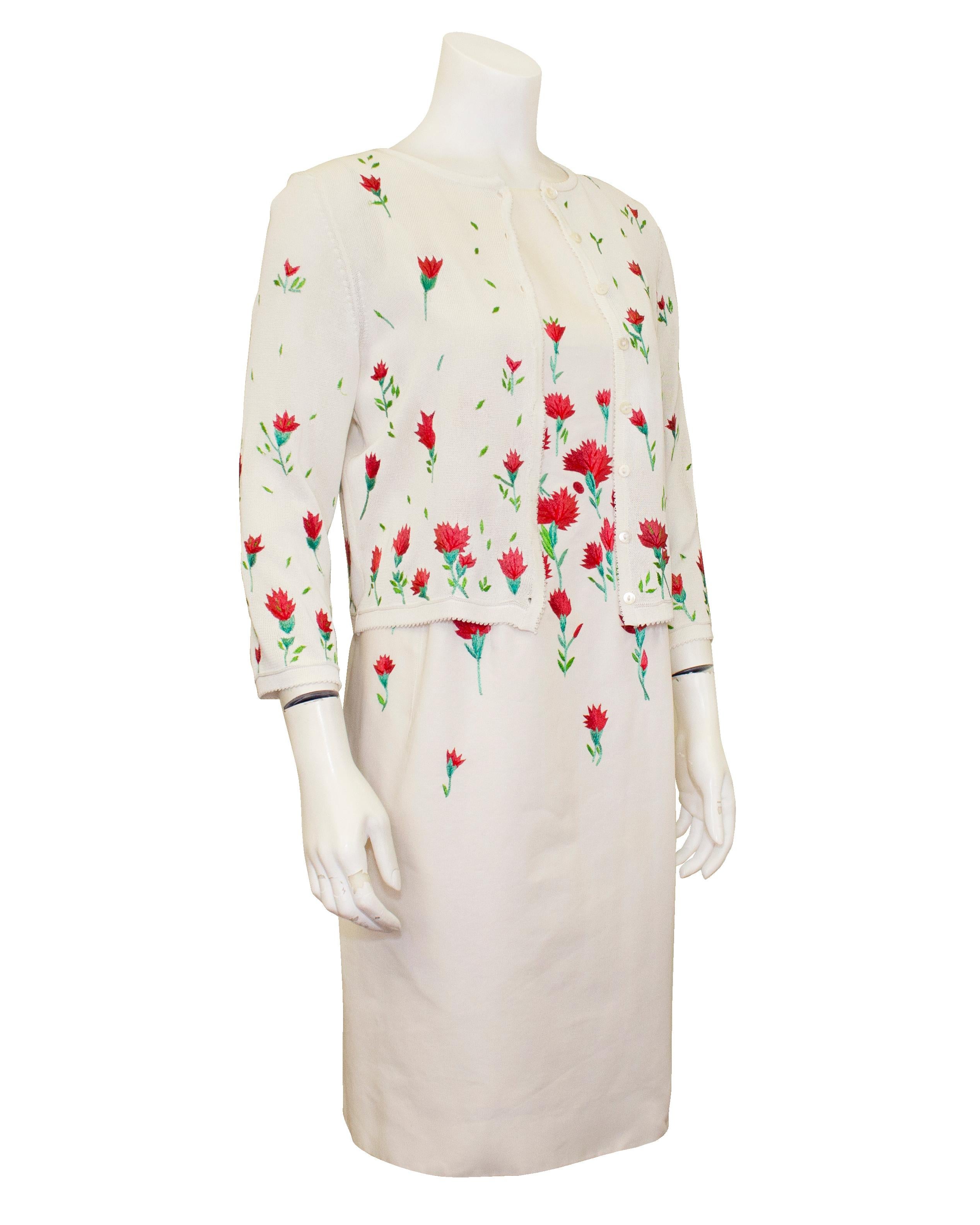 Extremely elegant Oscar de la Renta dress and cardigan ensemble from the the 2000s. Sleeveless, boatneck white cotton twill dress with beautiful embroidered pink, red and green carnations through at the waist, bust and hips. Lovely seam work