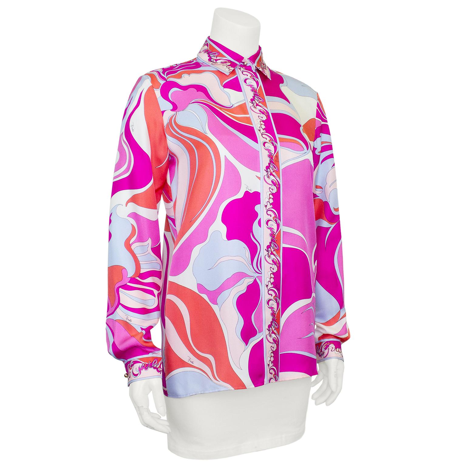 Absolutely stunning Emilio Pucci blouse from the early 2000s. Luscious silk with an all over abstract print in shades of orange, pink and pale blue. The collar, placket and cuffs read Emilio Pucci over and over in a beautiful abstract script. Gold