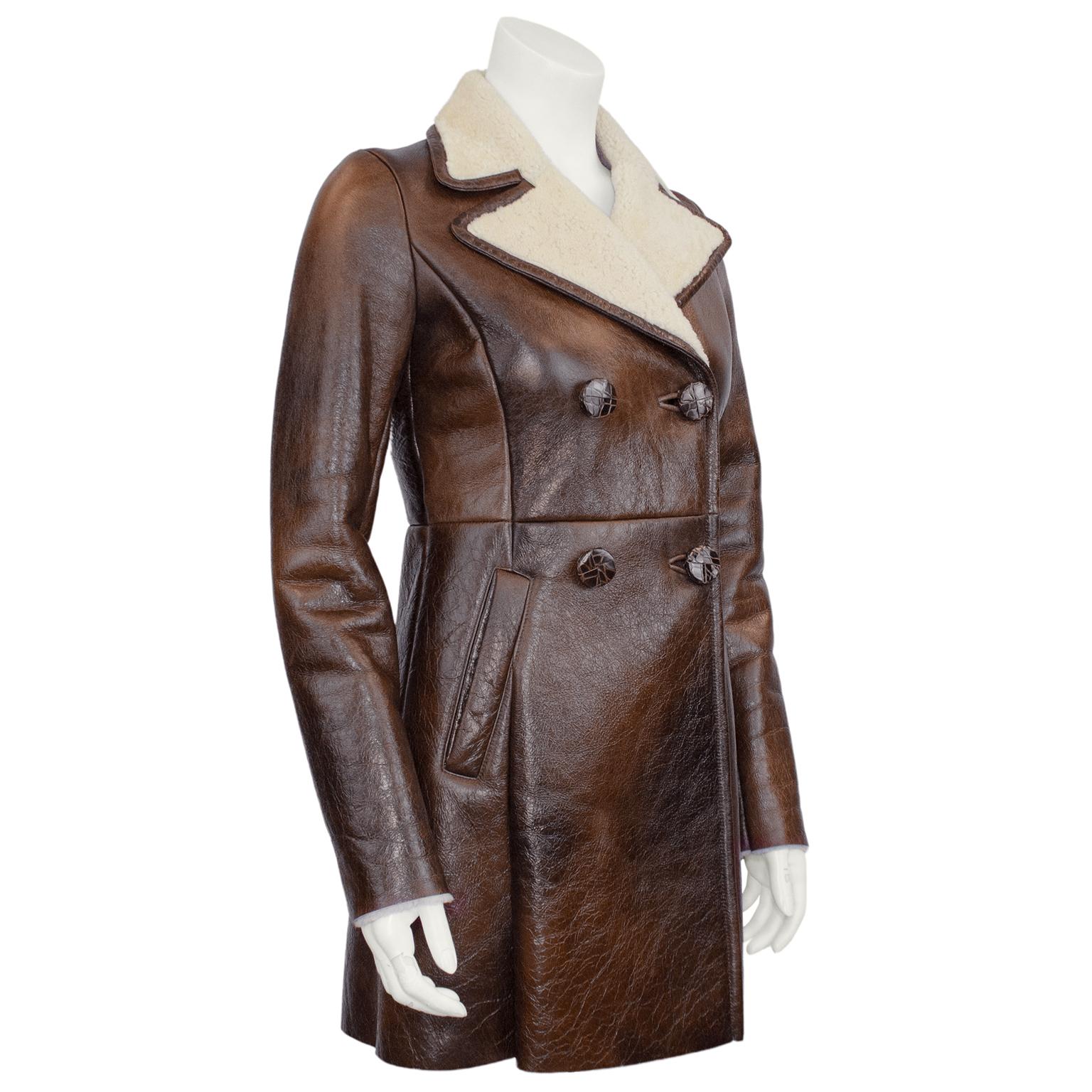 Beautiful Prada coat from the early 2000s. Distressed rich brown leather with contrasting cream shearling collar and interior. Double breasted with brown alligator buttons that look like reptile skin and diagonal slit pockets. Lovely seaming that