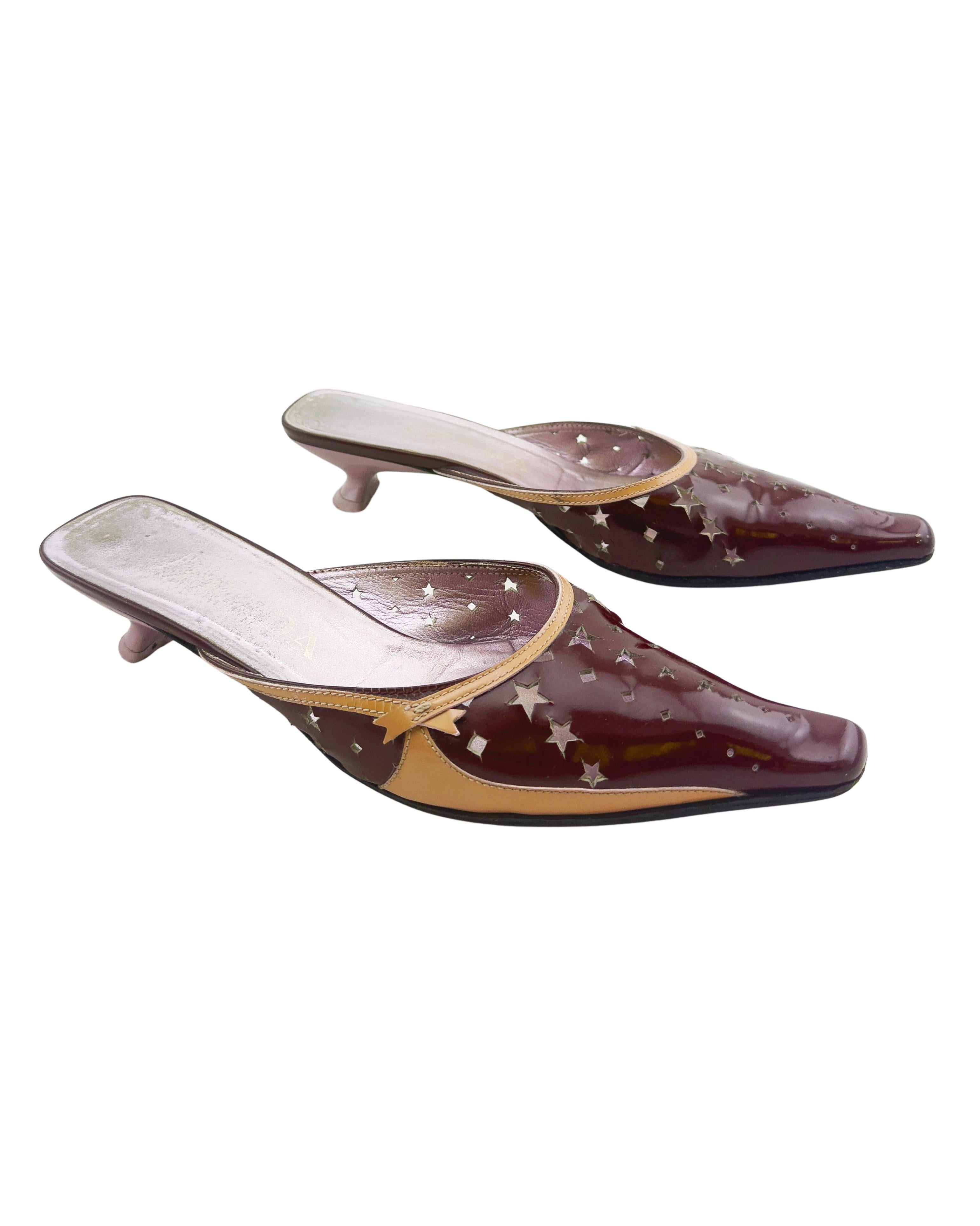Early 2000s Prada mules. Burgundy and tan patent leather with star and diamond shaped cut outs throughout and cream top stitching. Elongated rounded square toe and small light pink kitten heel. Good vintage condition - some signs of wear throughout,