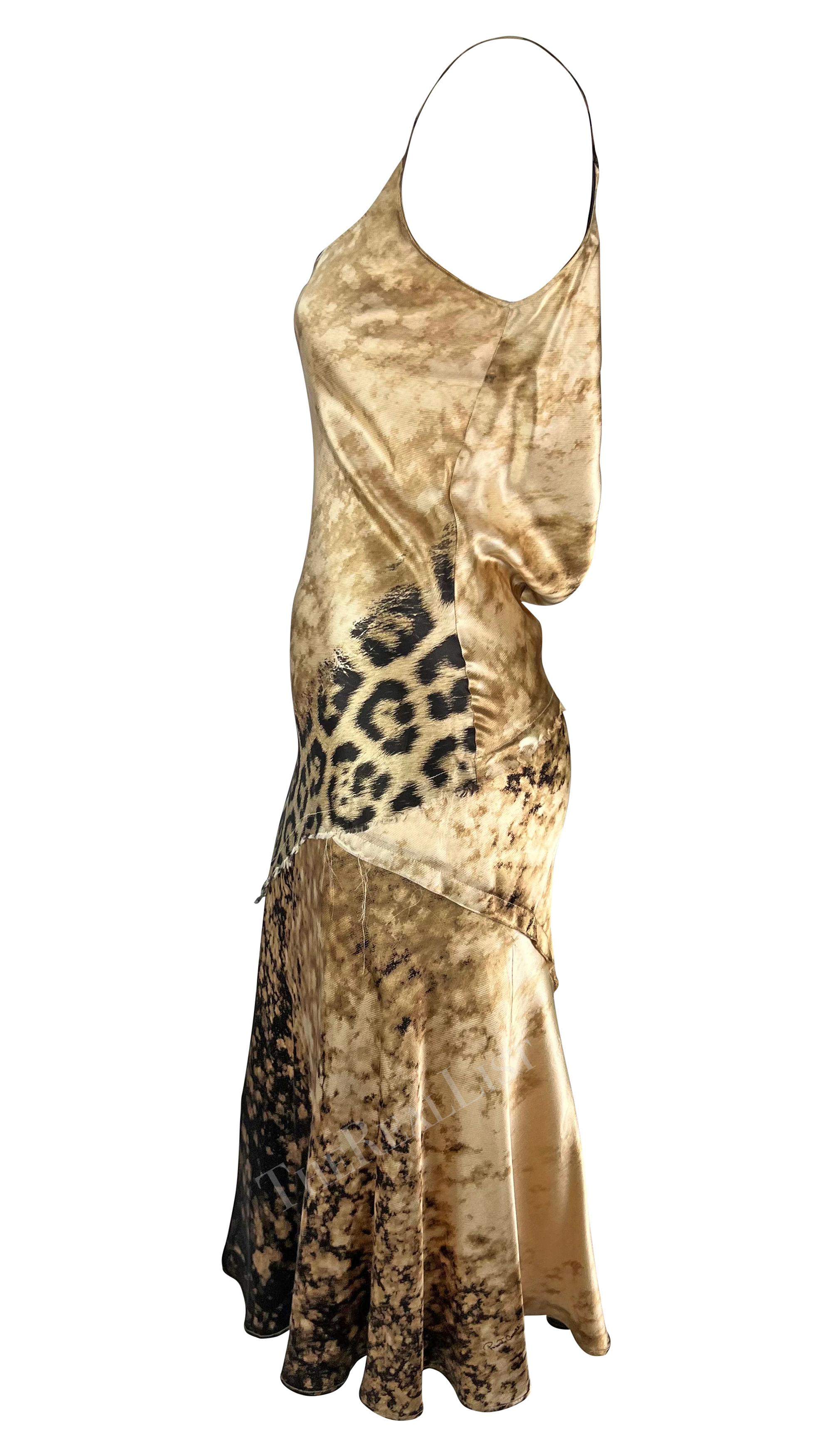 Presenting a stunning beige silk Roberto Cavalli slip dress. From the early 2000s, this gorgeous dress is covered in a tan abstract and leopard print. The dress features a scoop neckline, spaghetti straps, a flared hem, and a draped accent at the