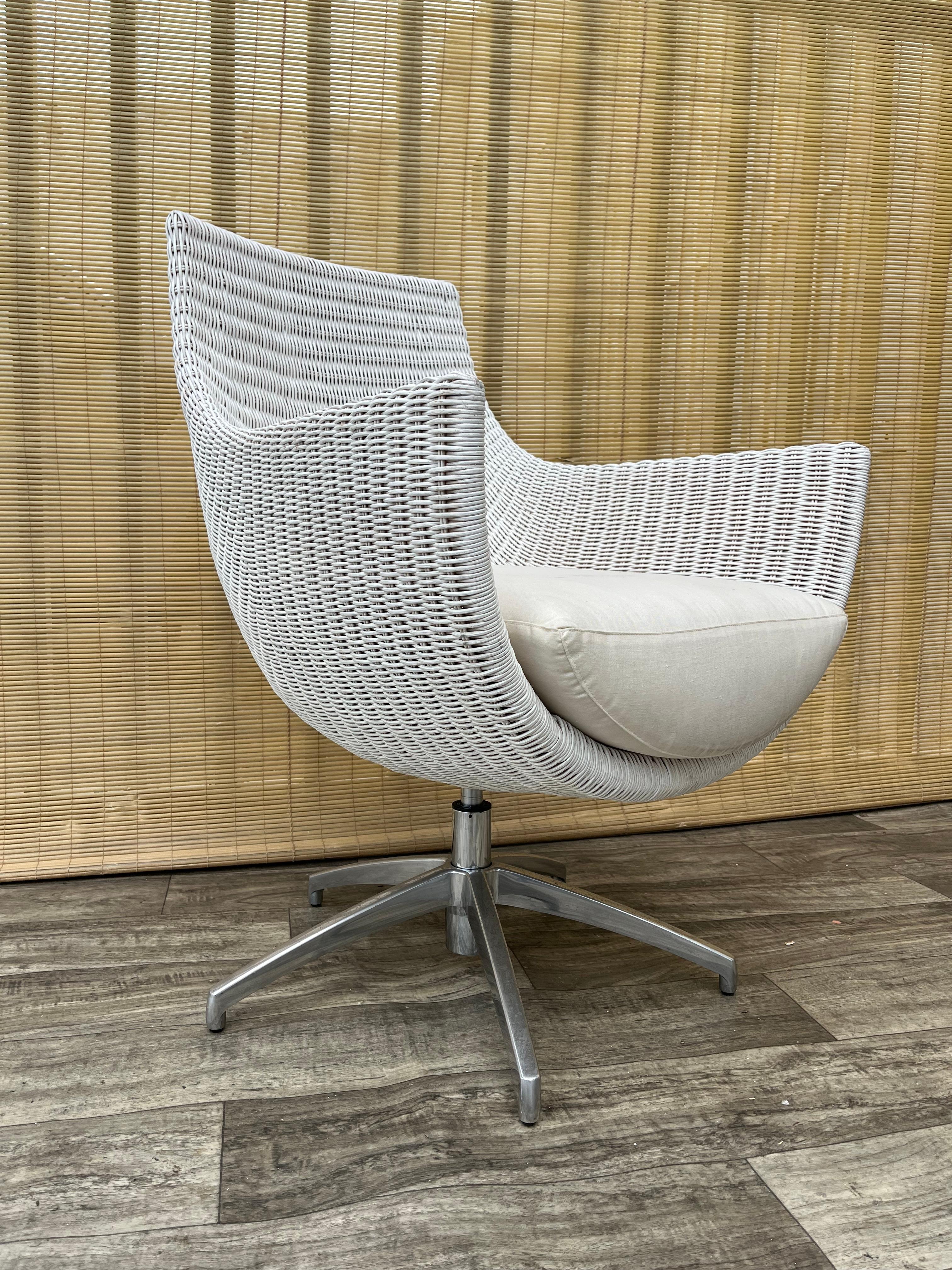 Silla de salón giratoria de mimbre vintage de principios de la década de 2000, de Palecek Furniture.
Presenta un diseño inspirado en la Silla Egg de Arne Jacobsen, una estructura de mimbre, una base giratoria cromada y cojines extraíbles tapizados