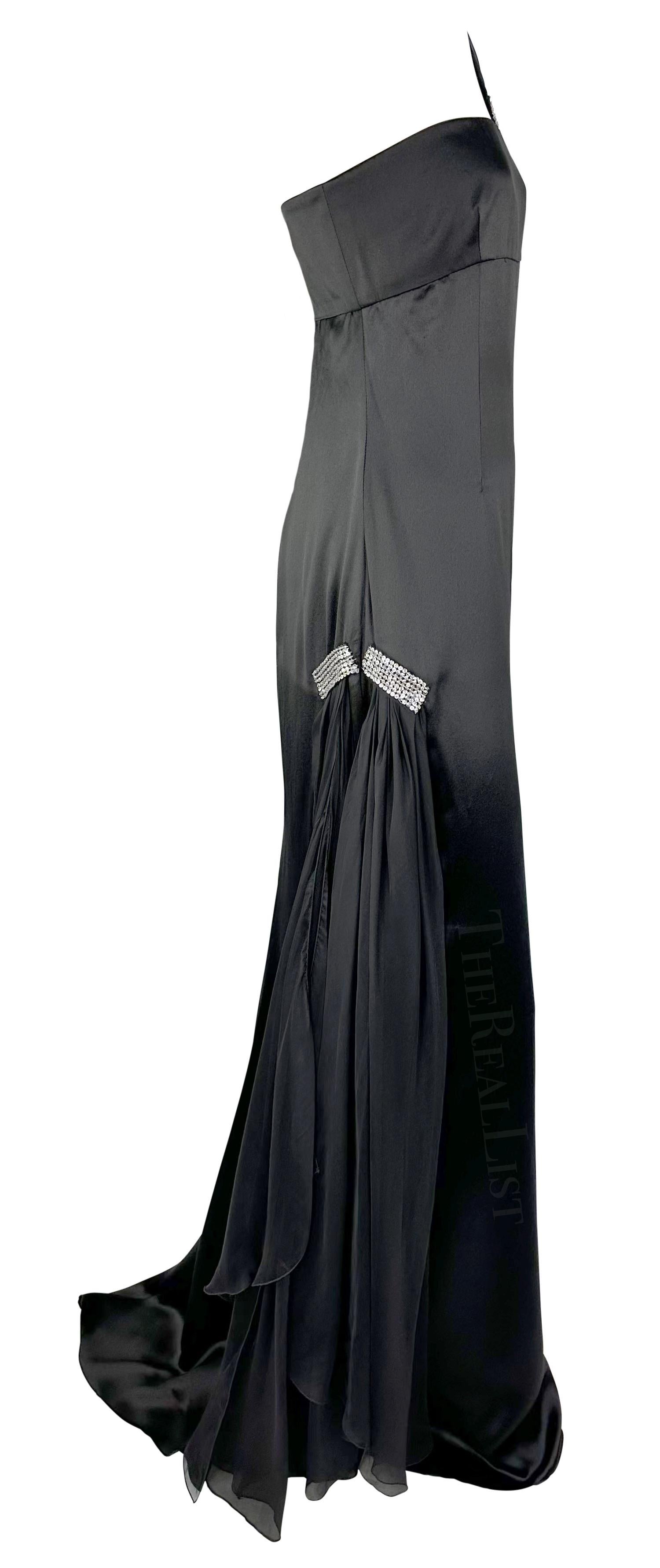 Presenting a glamorous black silk satin asymmetric gown. Designed by Valentino Garavani in the early 2000s, this floor-length dress is constructed entirely of silk satin and features a single shoulder strap, small train, and silver-tone sequins