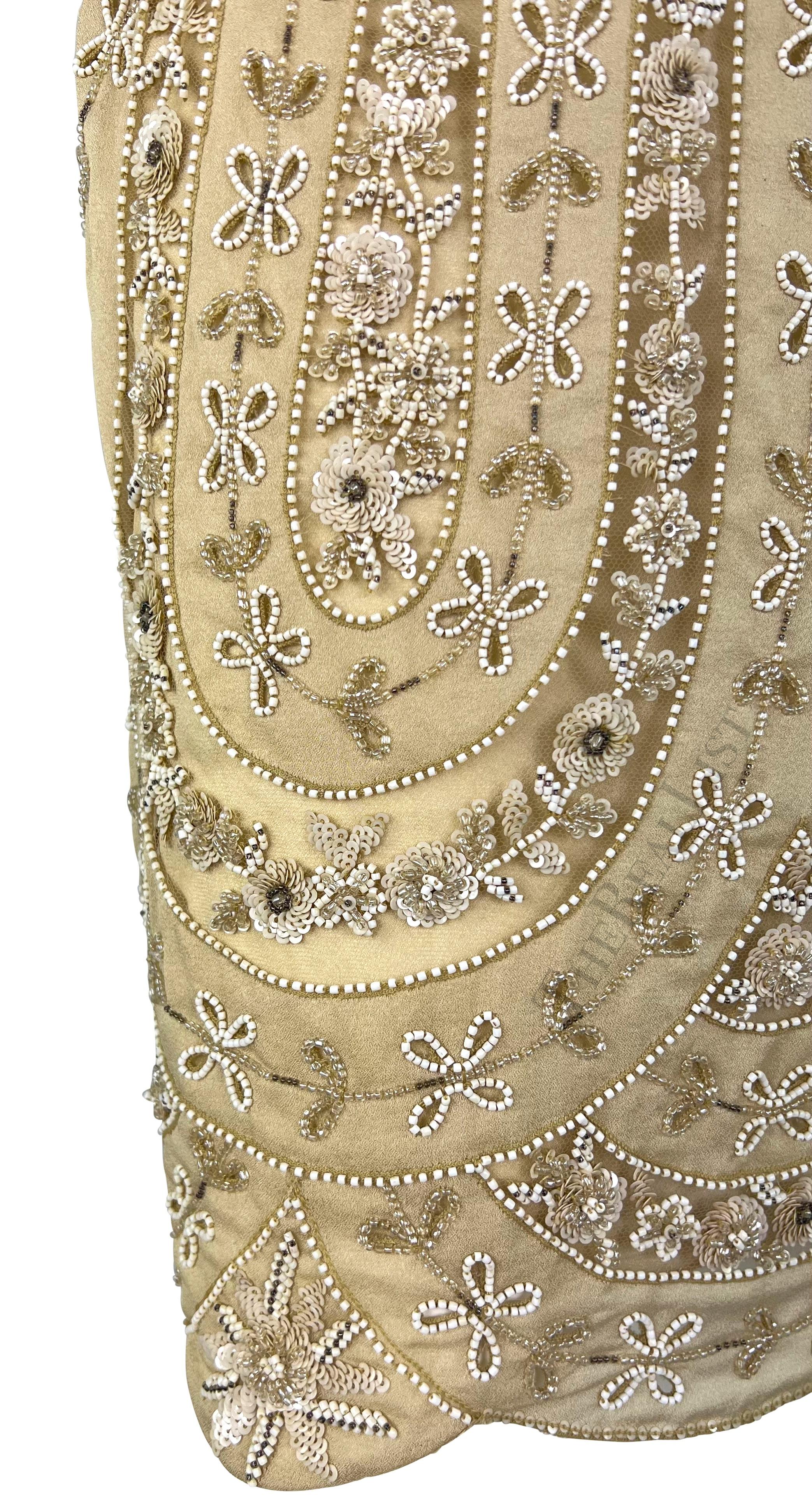 Presenting a fabulous beige beaded Valentino skirt. From the early 2000s, this intricate skirt is covered in a hand-beaded floral pattern. The skirt features a scalloped hem and is made complete with sheer mesh panels atop the underskirt. Truly a