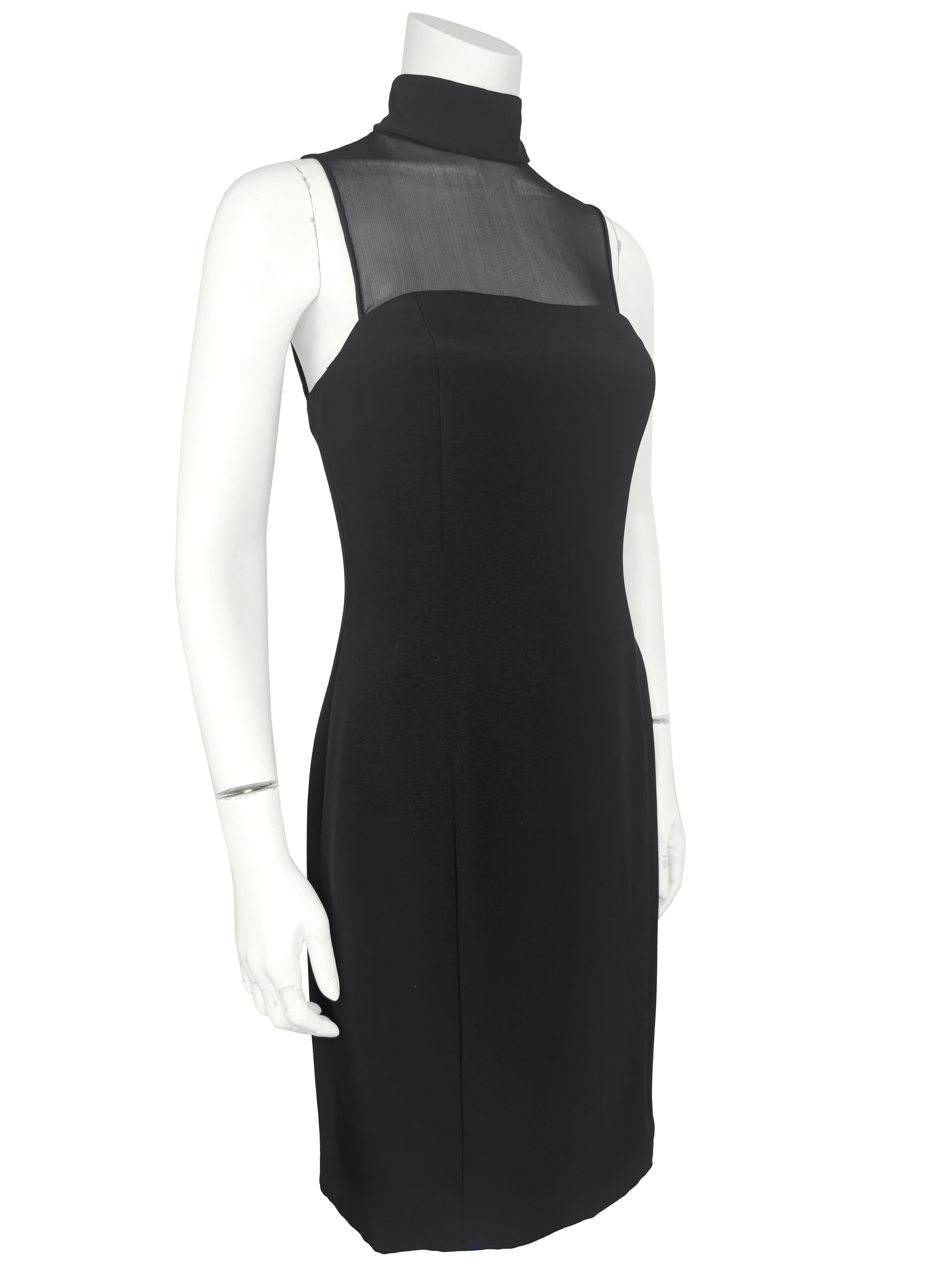 Early 2000s Vera Wang black body con illusion turtleneck little black dress. A departure from her usual white wedding gowns, this sexy LBD has the shape of a strapless dress with a sheer panel that attaches to a black silk turtleneck. Trimmed in the