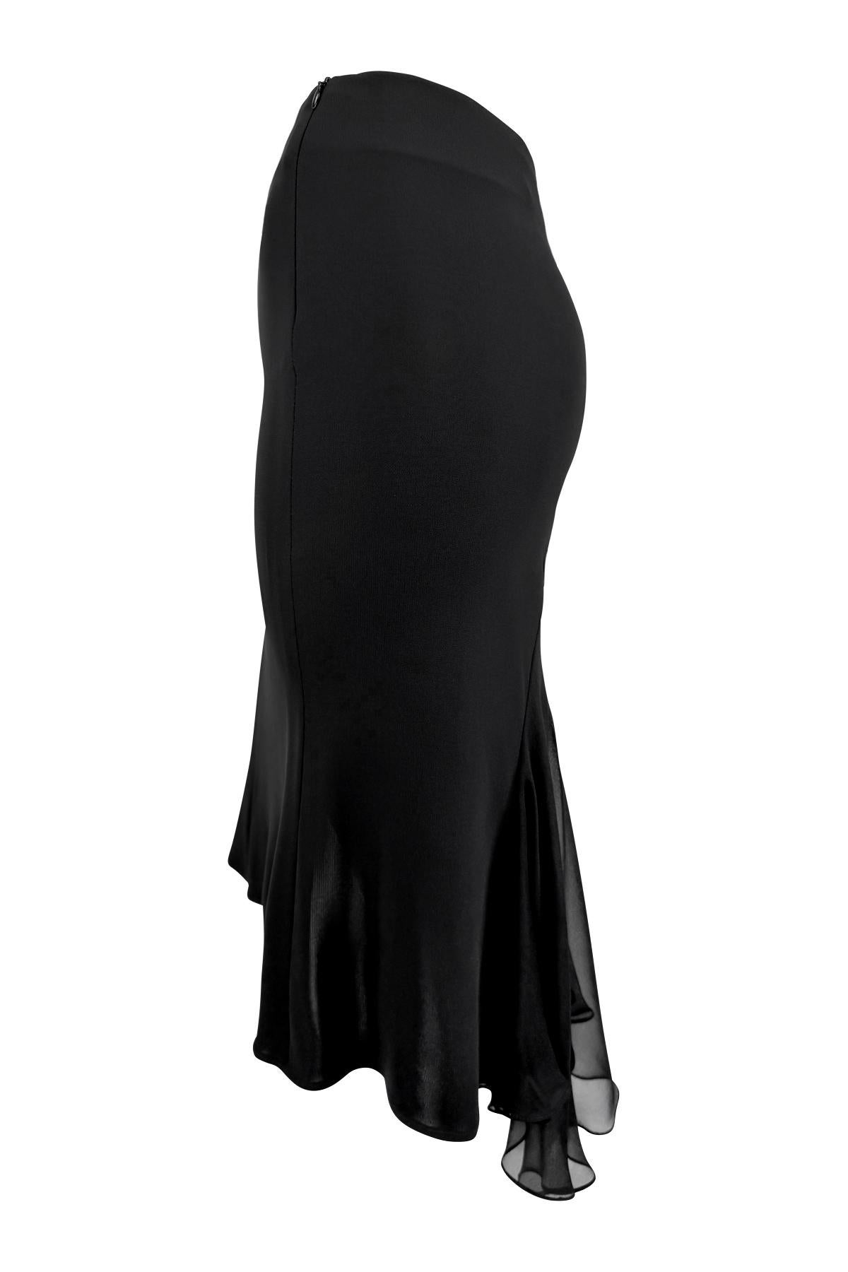 This early 2000s Yigal Azrouël midi skirt is crafted from black stretch jersey and features a body-skimming silhouette with chiffon paneling. Designed with an asymmetrical hemline that dips longer at the back, the skirt is finished with a softly