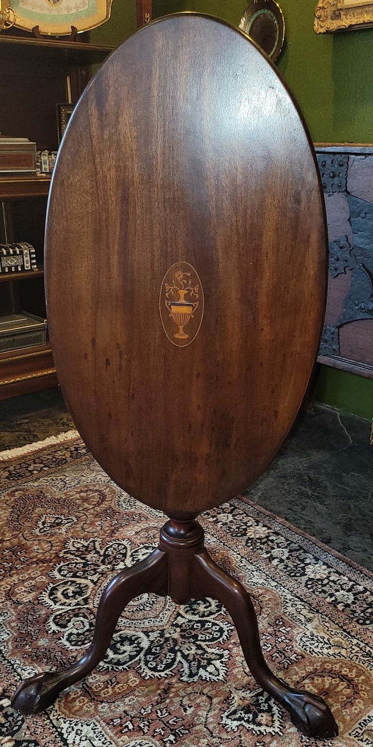PRESENTING a LOVELY Early 20C English Oval Tilt Top Ball and Claw Side Table.

Made in the Regency/Sheraton/Chippendale Style in England circa 1900-20.

The serial numbers on the ‘bird cage’ area of the base tell us that it is a 20C piece but the