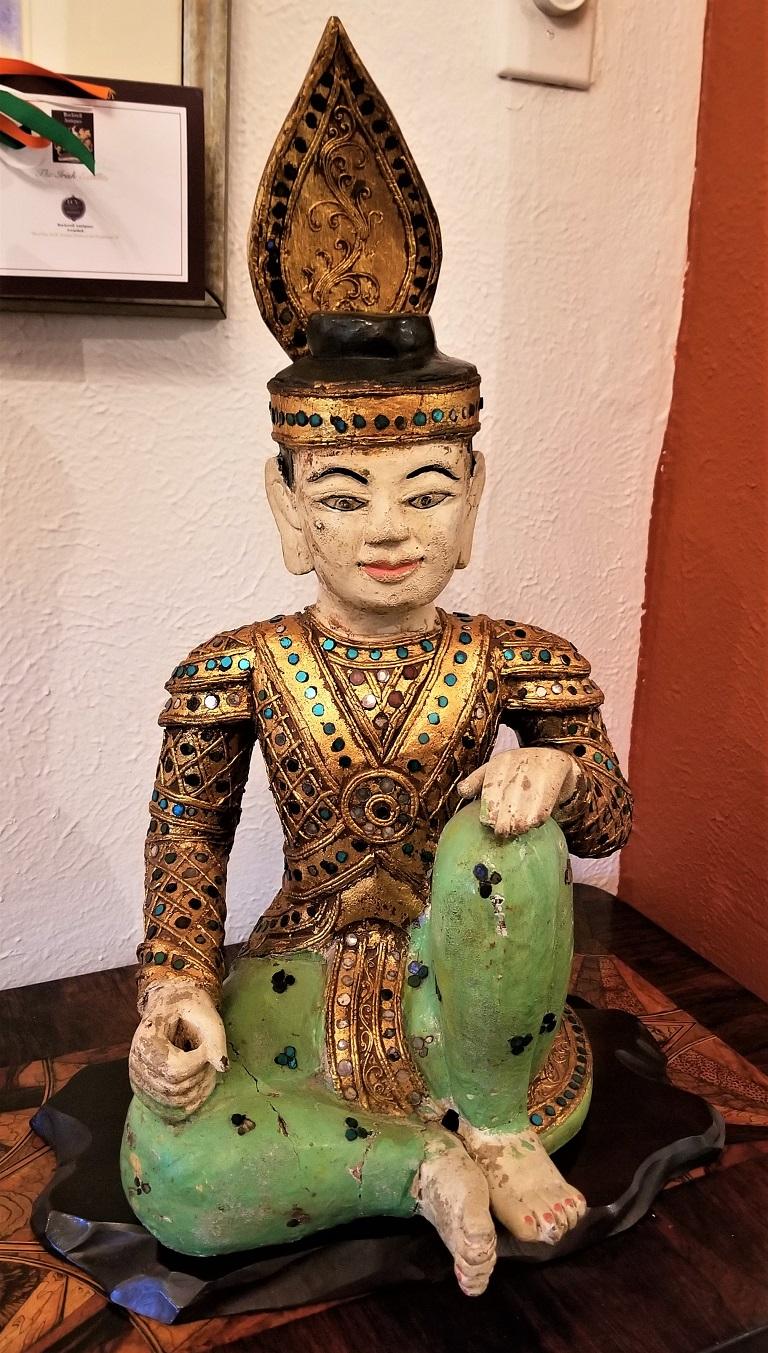 Wir präsentieren eine prächtige thailändische sitzende Knaben-Kaiser-Statue aus dem frühen 20.
Hergestellt in Thailand im frühen 20. Jahrhundert, ca. 1935-1940.
Handgeschnitzte Holzstatue, die allseitig handbemalt (polychromiert) ist. Der