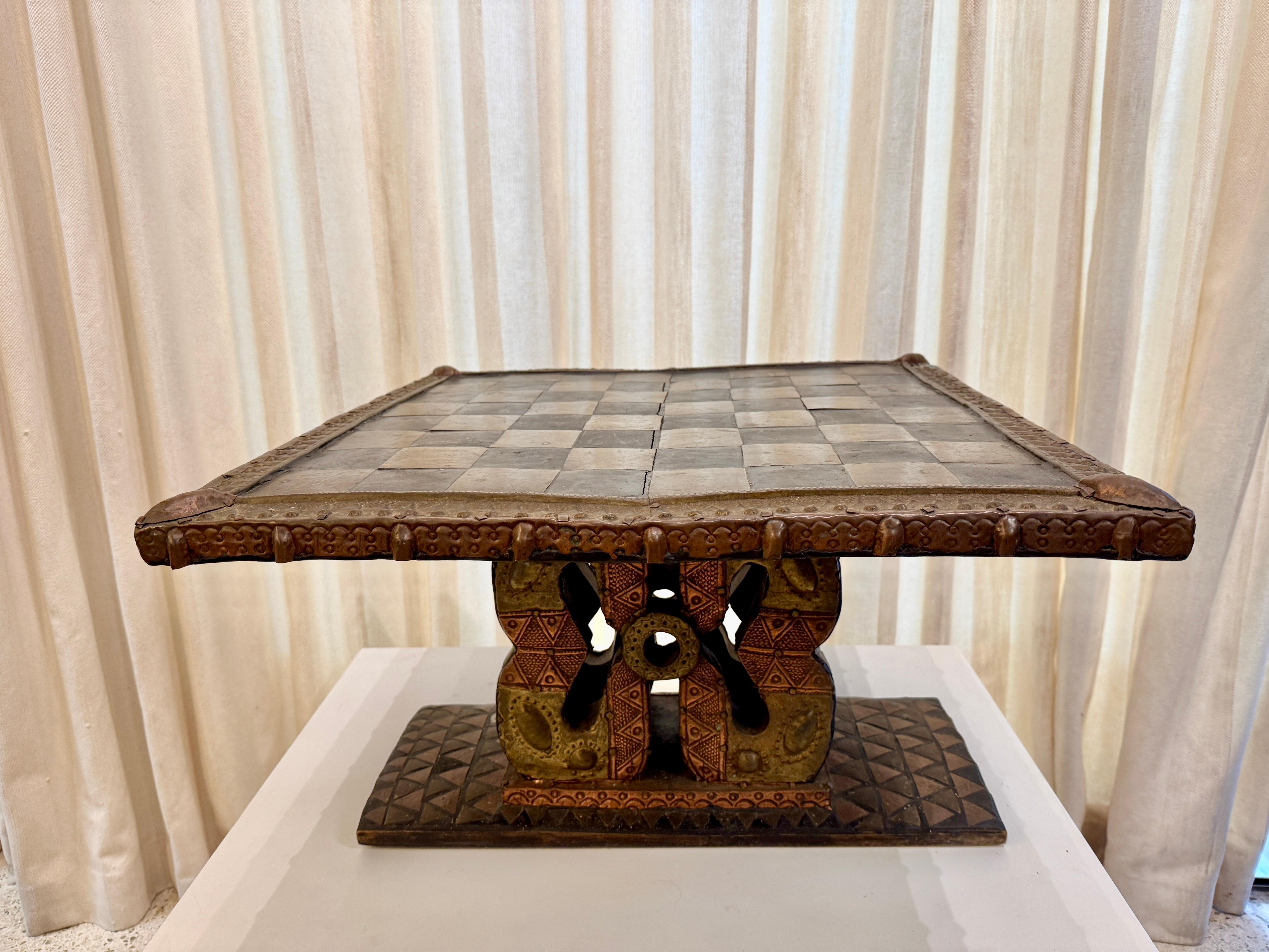 Dieser niedrige afrikanische Schachtisch aus dem frühen 20. Jahrhundert ist aus Messing, Kupfer und lackiertem Metall gefertigt und hat einen wunderschönen Holzsockel.  Tolle Details durch handwerklich gehämmertes Metall - wirklich ein Kunstwerk. 