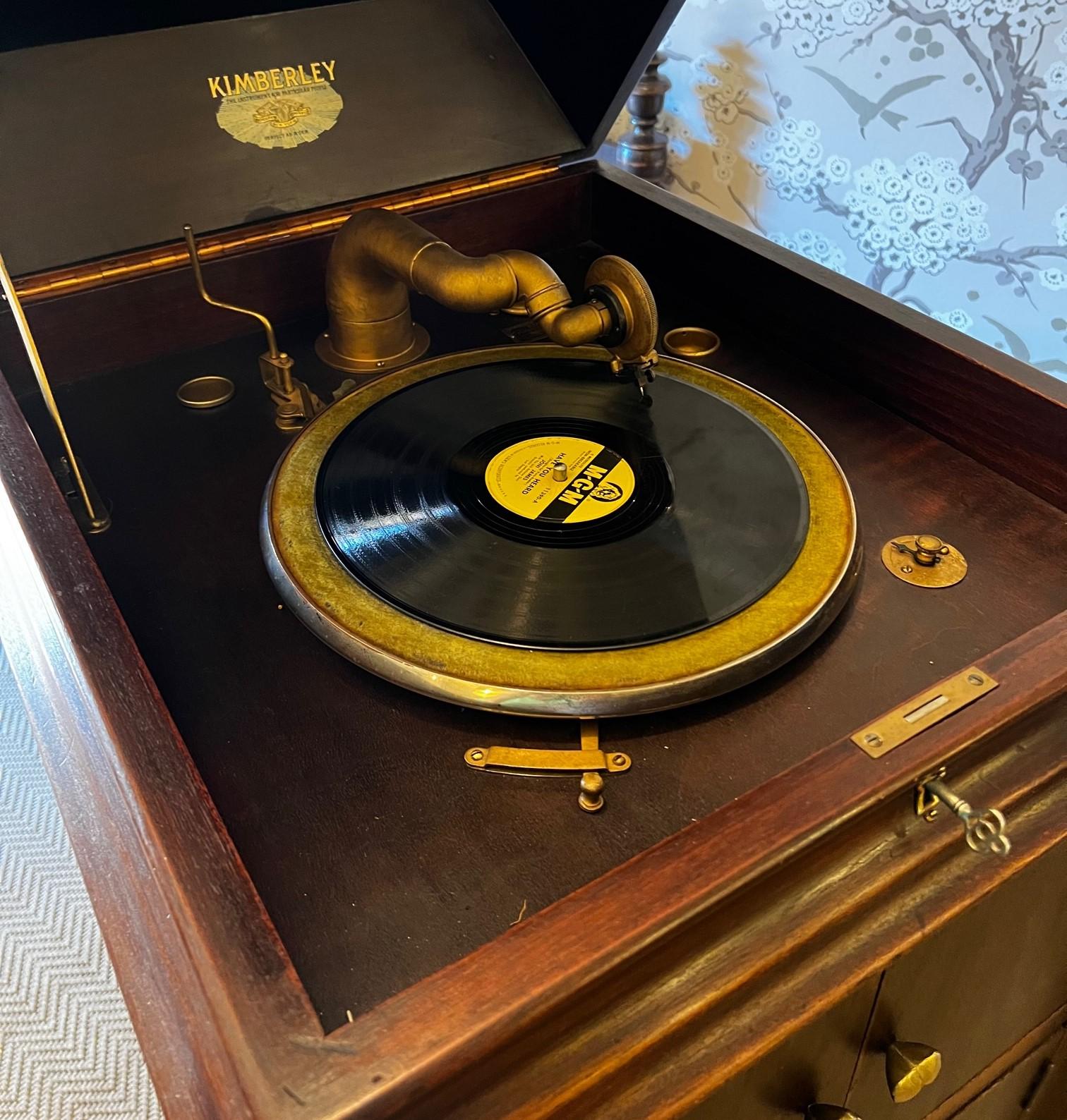 Early 20th C. American phonograph, produced by the Kimberley Phonograph Company, as indicated by the plaque on the inside of the cabinet. The phonograph is housed in a wooden cabinet, featuring a classic, polished finish with brass hardware, and a