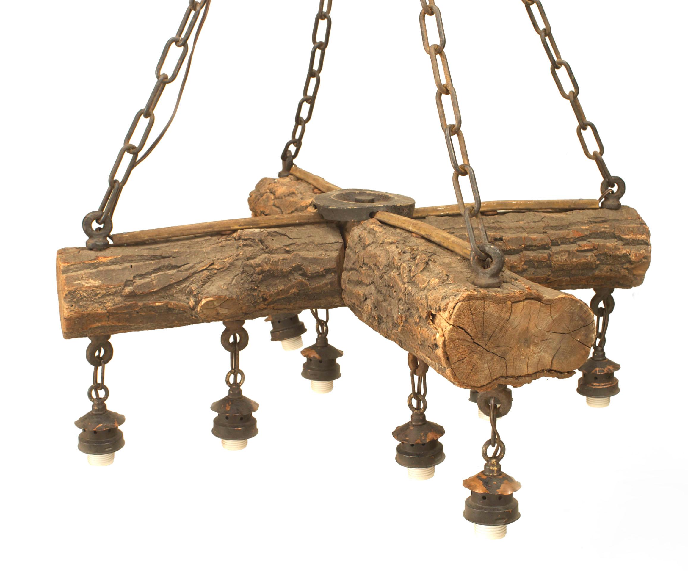 Rustic Adirondack-style (1st Quarter 20th Century) chandelier with two crossed logs supporting 8 drop lights and 4 iron chains connected to a canopy.
