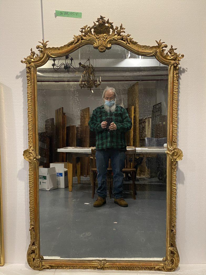From early 20th century France, an elegant gold gilded gesso and carved wood mirror with intricate floral decorative details. Original mirror has attractive minor spotting and aging. This can be seen at our 333 West 52nd St location in the Theater