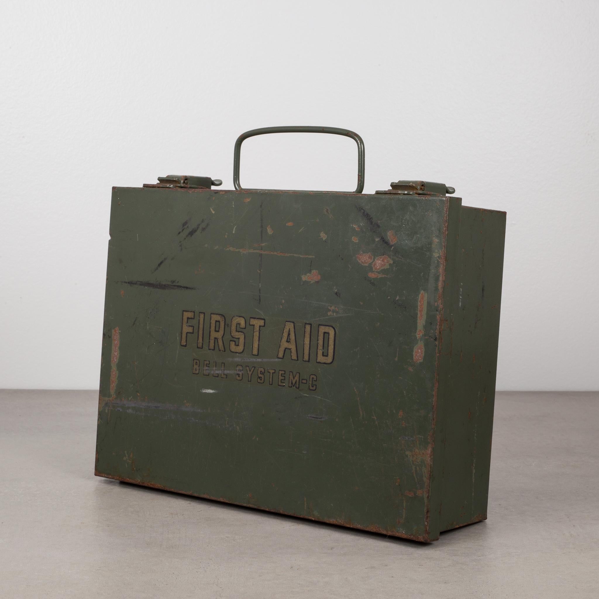 This is an original vintage metal first aid kit. The box is filled with medical items in their original boxes including bandage, Iodine, petroleum jelly, burn cream and a pair of scissors still in their wrapper. The original finish has the