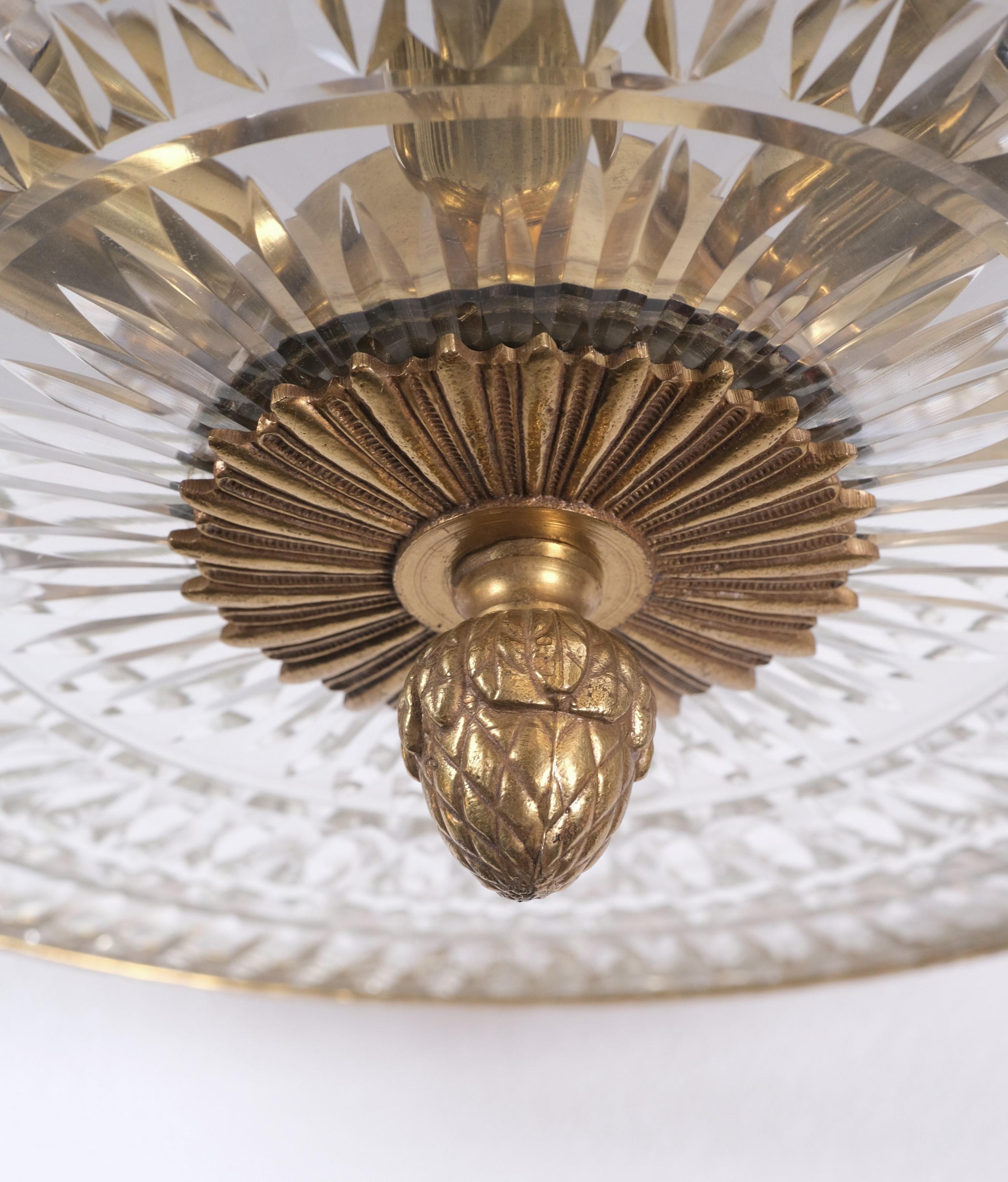 Early 20th century ornate brass semi flush mount ceiling light. French design with fleur-de-lis around the outside and an acorn finial on bottom. Cut glass shade. Six sockets, cleaned and rewired. This can be seen at our 333 West 52nd St location in