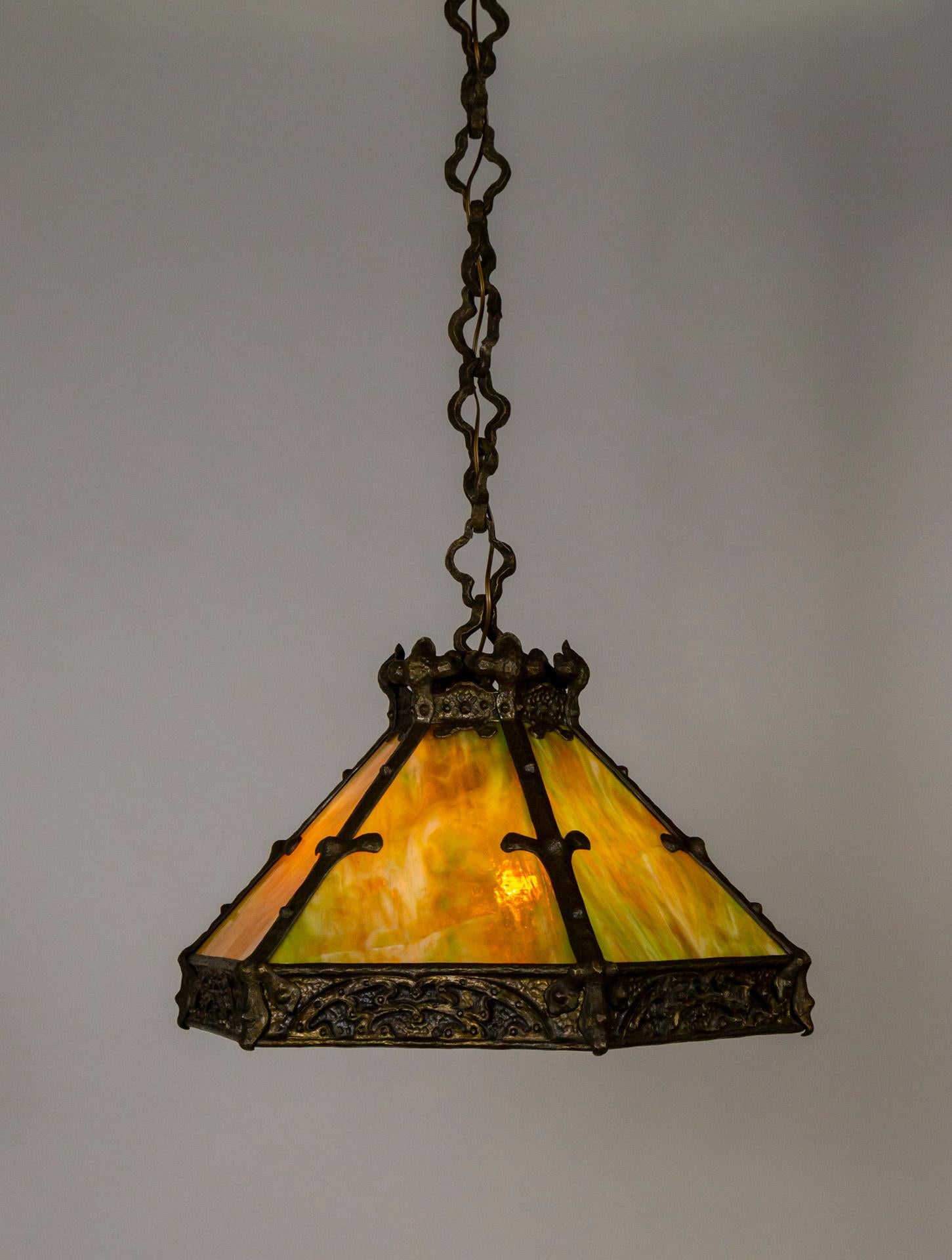 Arts & Crafts Peroid, Craftsman style, chandelier/pendant with Art Nouveau and Gothic influences. Rich amber and green slag, art glass shade. Detailed castings . 55