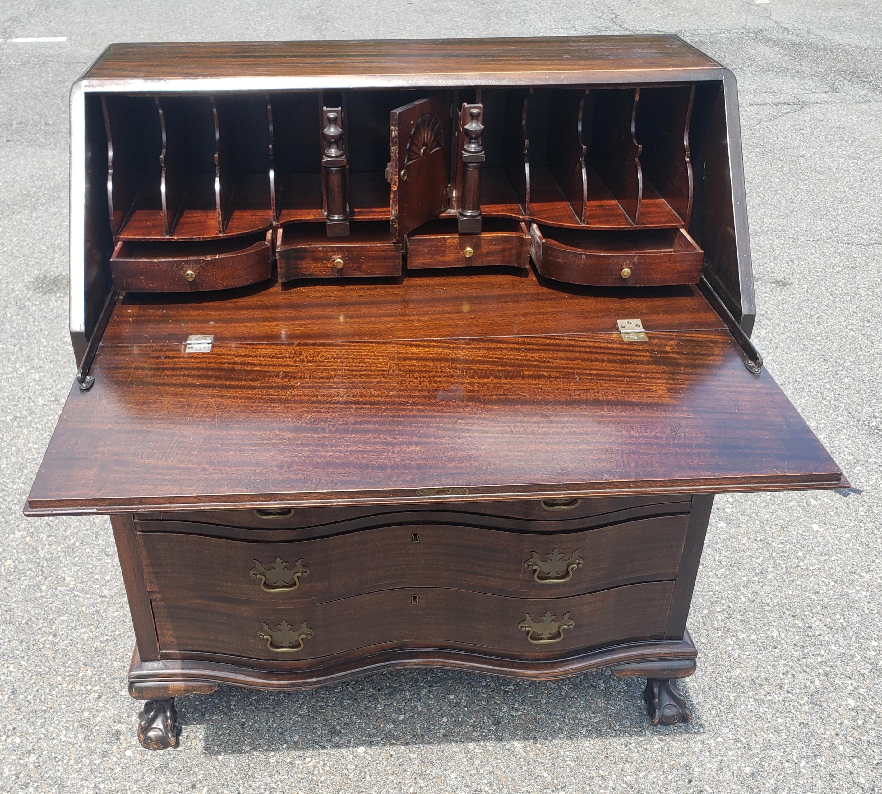 An early 20th century Chippendale Style Mahogany Oxbow Slant Front Secretary Desk. 4 dovetailed Serpentine drawers. Slant front door opens to reveal addition storage space with 5 small drawers and plenty of additional  storage space.
Measures 46