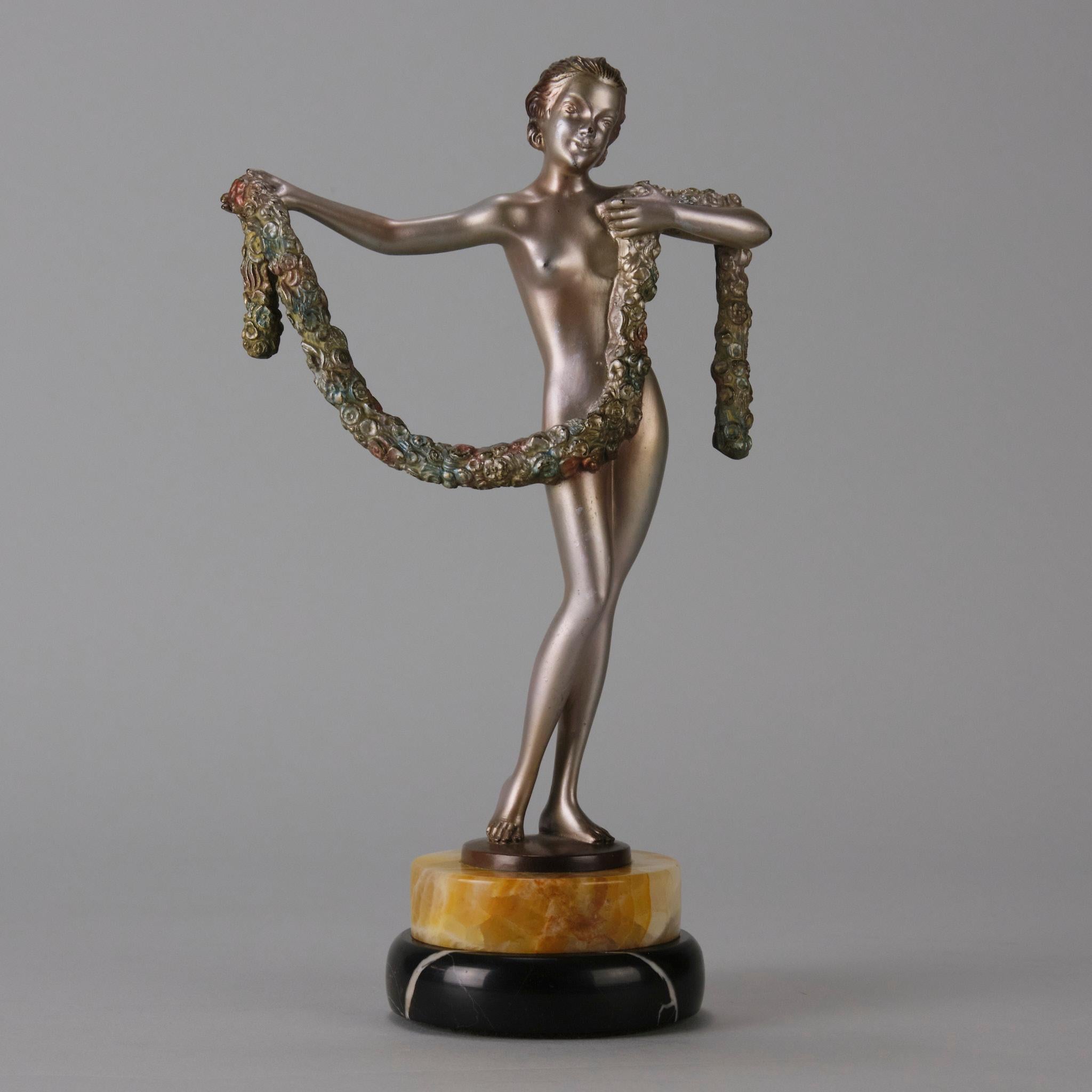 A fabulous early 20th Century Art Deco cold painted silver and enamel bronze figure of a dancer holding a garland of flowers in her arms, raised on a circular stepped onyx and marble base and signed to base rim Lorenzl

Additional