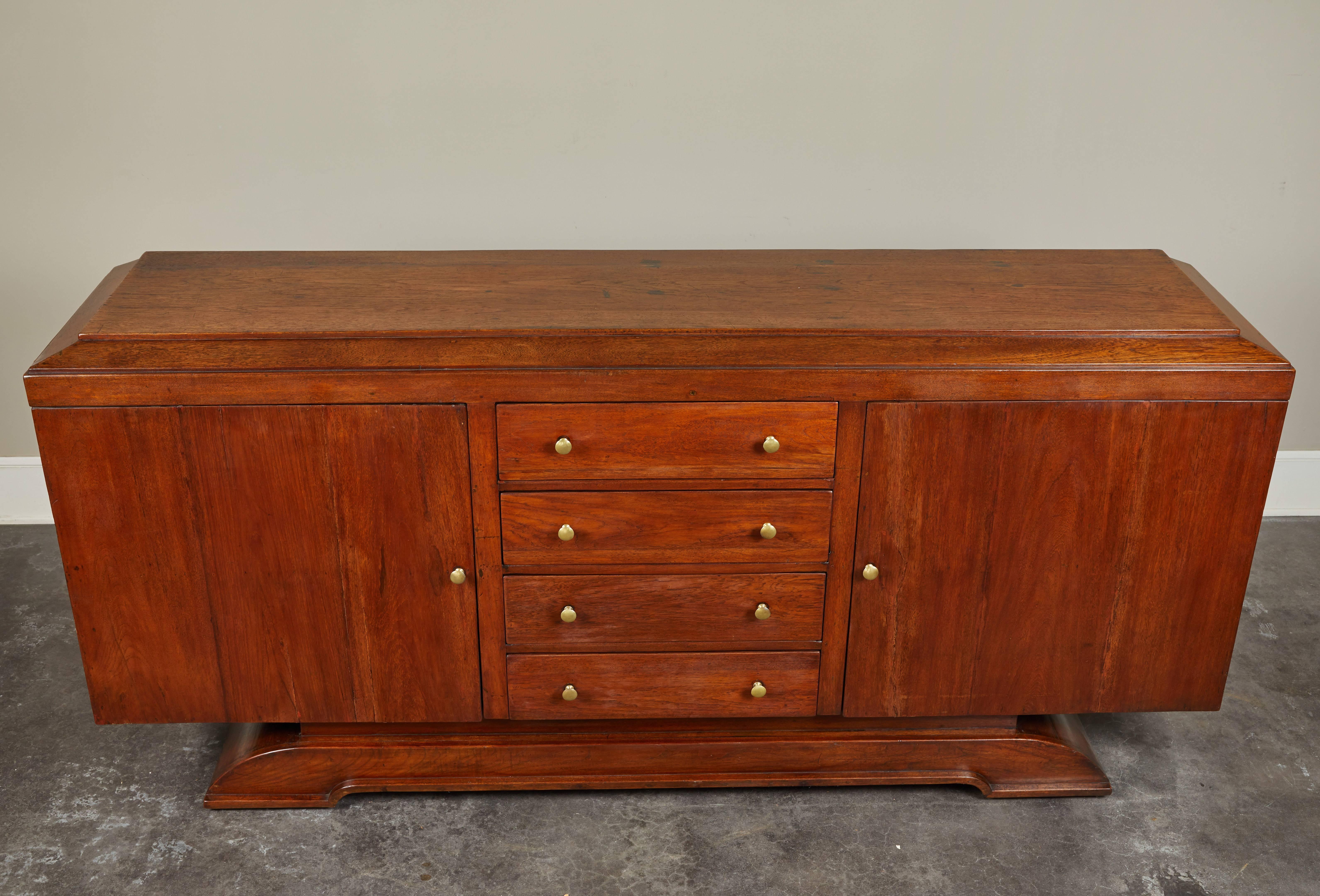 An early 20th century colonial Art Deco style rosewood sideboard. Four center drawers and two large hinge doors with single shelves. Larger scale, perfect for dining room storage, entryway organization or secondary storage in a bedroom.