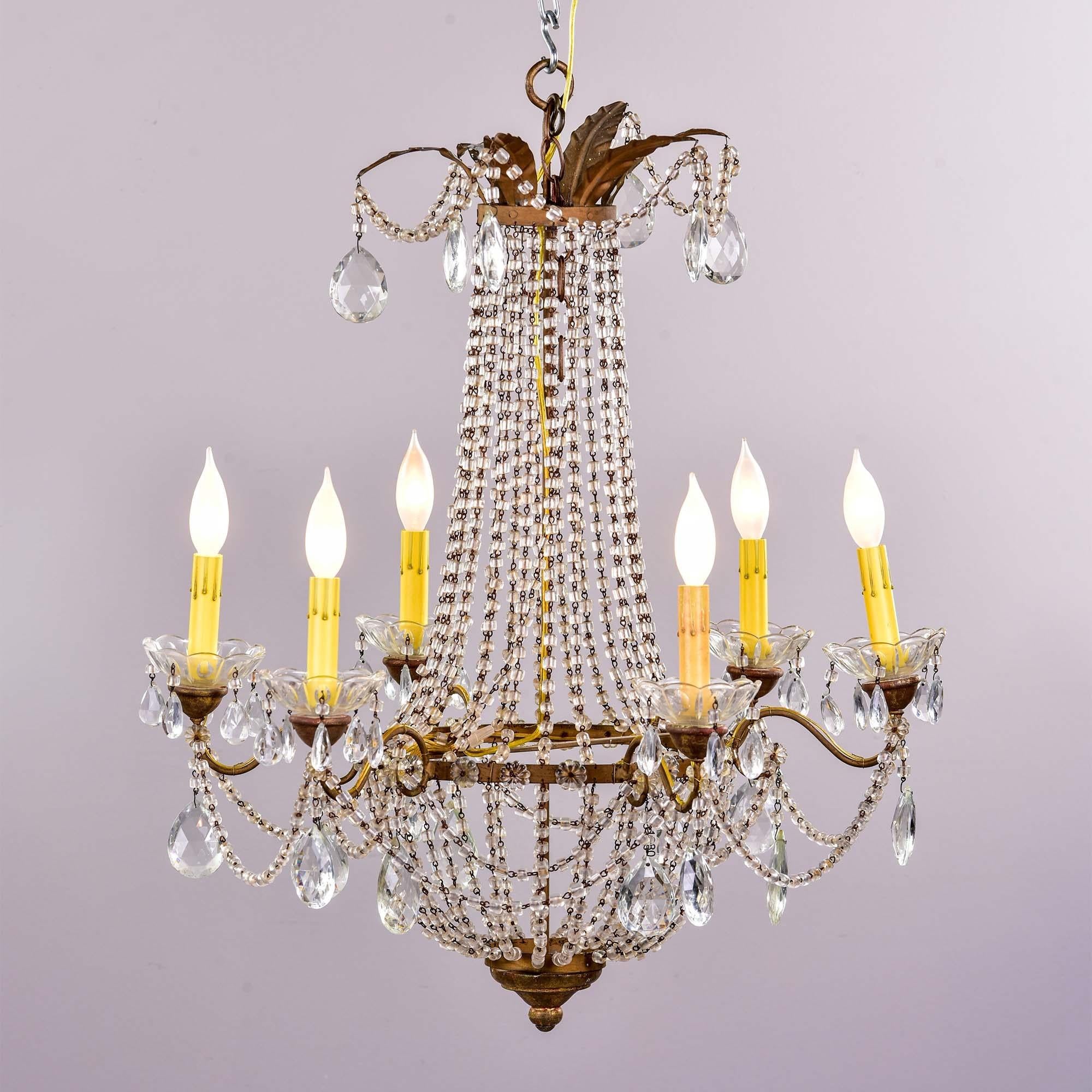 Early 20th C Empire style six light chandelier

Found in Belgium, this circa 1930s empire style chandelier features six candle style lights surrounding a basket form bowl created with draped strings of clear, barrel shaped crystals. Each light has