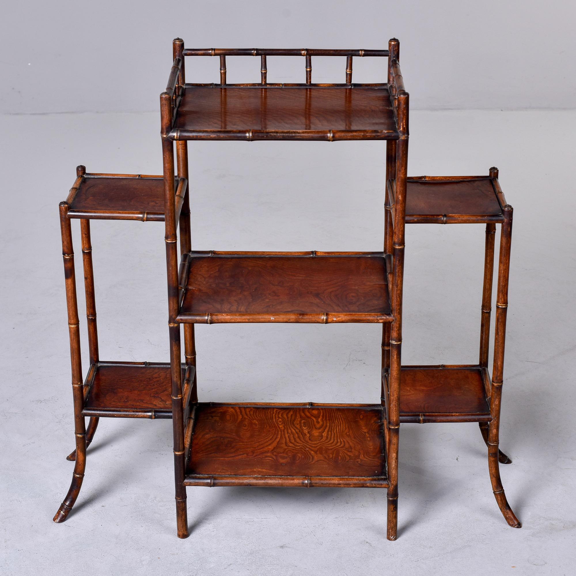 Circa 1910 three section English bamboo and wood etagere / display / plant stand. Versatile size at just under three feet tall and wide. Can be used to display plants, pottery, art or glass. Unknown maker. Very good antique condition with minor