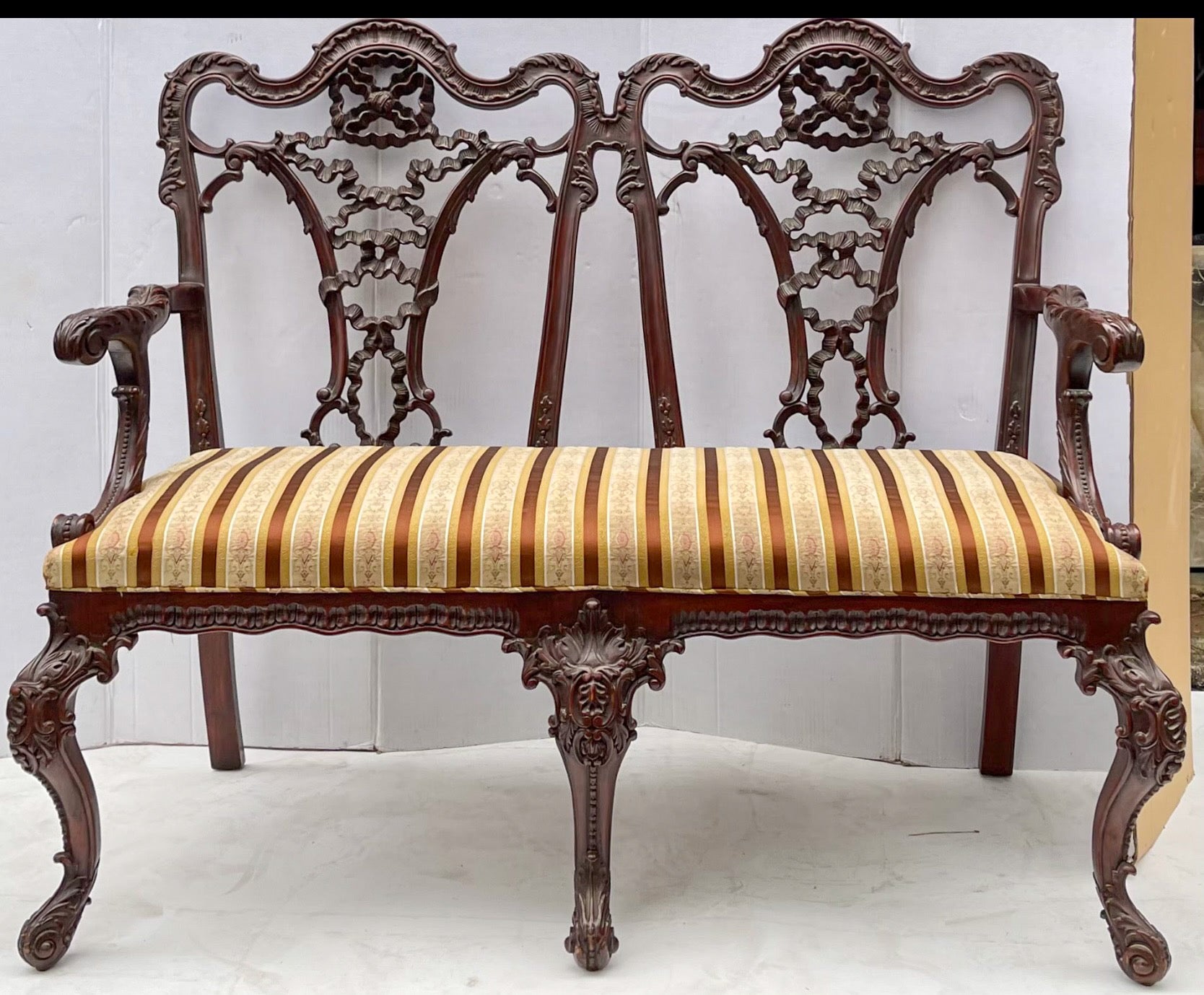 Such a beautiful back! This is an early English Chinese Chippendale style mahogany settee. The carving is amazing! The vintage striped upholstery is in very good condition. It is unmarked. 
My shipping is for the Continental US only.