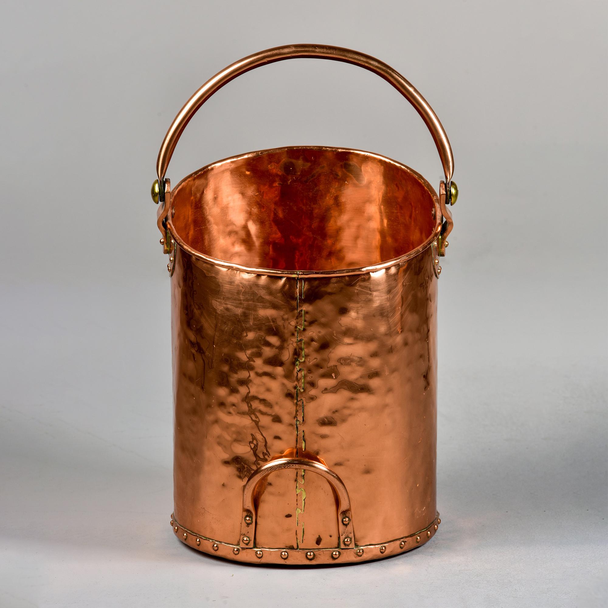 Circa 1920s large English coal bucket of hammered copper with handle at top and base. 

Height shown does not include handle. With handle in upright position, the bucket is 24.75