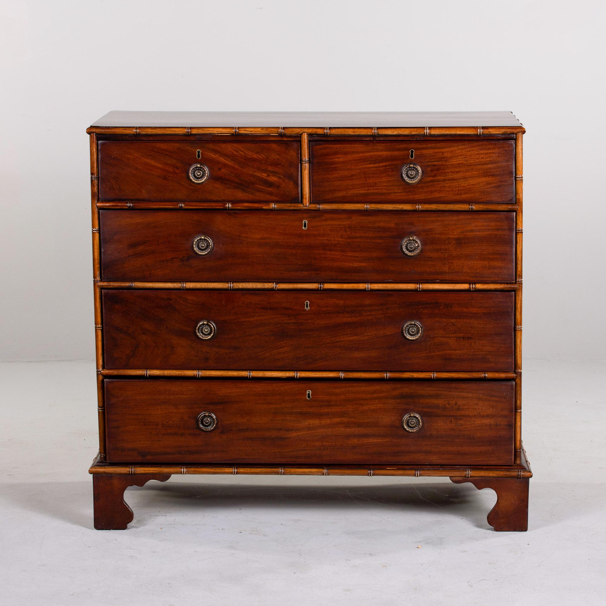 Found in England, this five drawer chest dates from the 1920s. Dark stained mahogany chest consists of two smaller top drawers with three larger drawers below. Brass ring-pull hardware, decorative bamboo trim and feet. Unknown maker. 

Very good