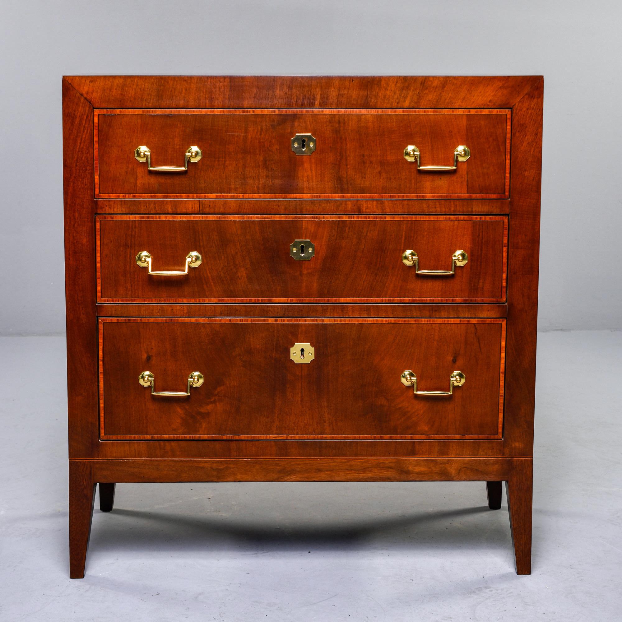 Circa 1920s English chest of three drawers with brass hardware. Dovetail construction, contrasting inlay details on drawer fronts, sides and top of chest. Unknown maker.