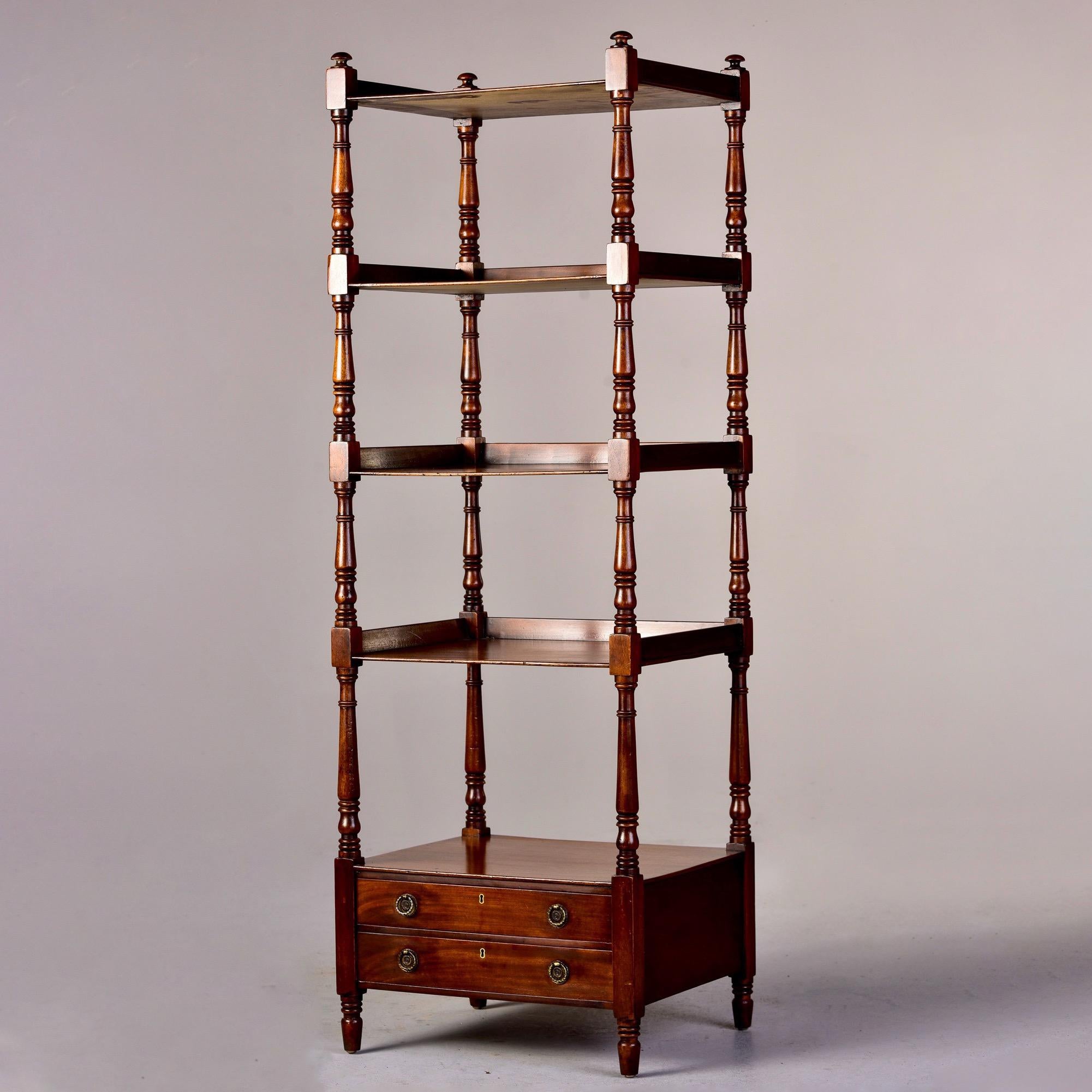Circa 1920s English four tier mahogany etagere or what not shelves with two small drawers at base. Turned supports, original brass hardware, versatile size. Unknown maker. Very good antique condition with scattered surface wear. Key to drawers is