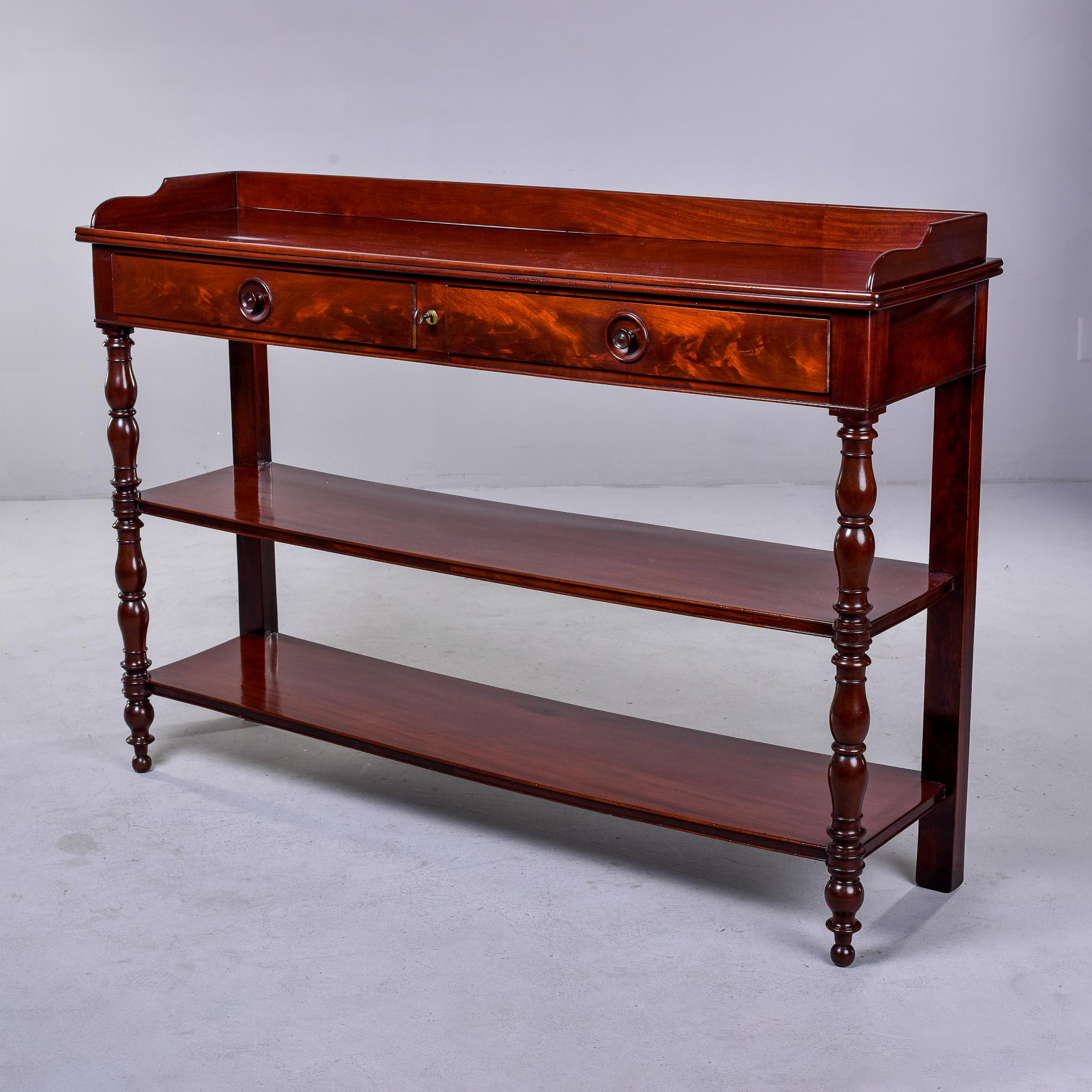 Found in England, this circa 1900 mahogany server table has a top with two drawers that have a functional lock and two lower tier shelves. Decorative turned legs in the front,nicely figured mahogany throughout. Unknown maker.

Very good overall