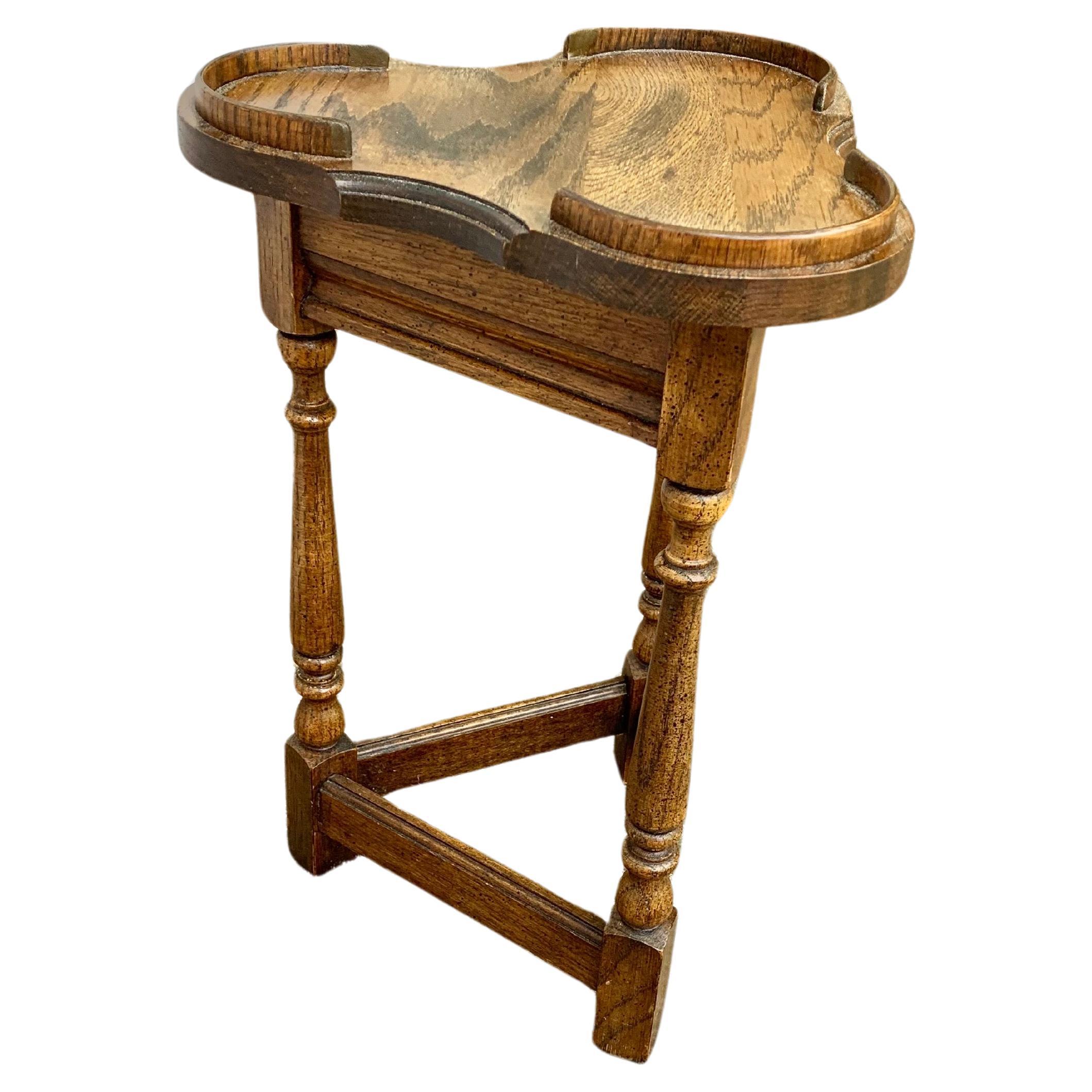Trouvée en Angleterre, cette table d'appoint Cricket Clover a été fabriquée par des artisans anglais à partir de chêne ancien au début du 20e siècle. La table présente un plateau en forme de trèfle reposant sur une frise triangulaire et une base en