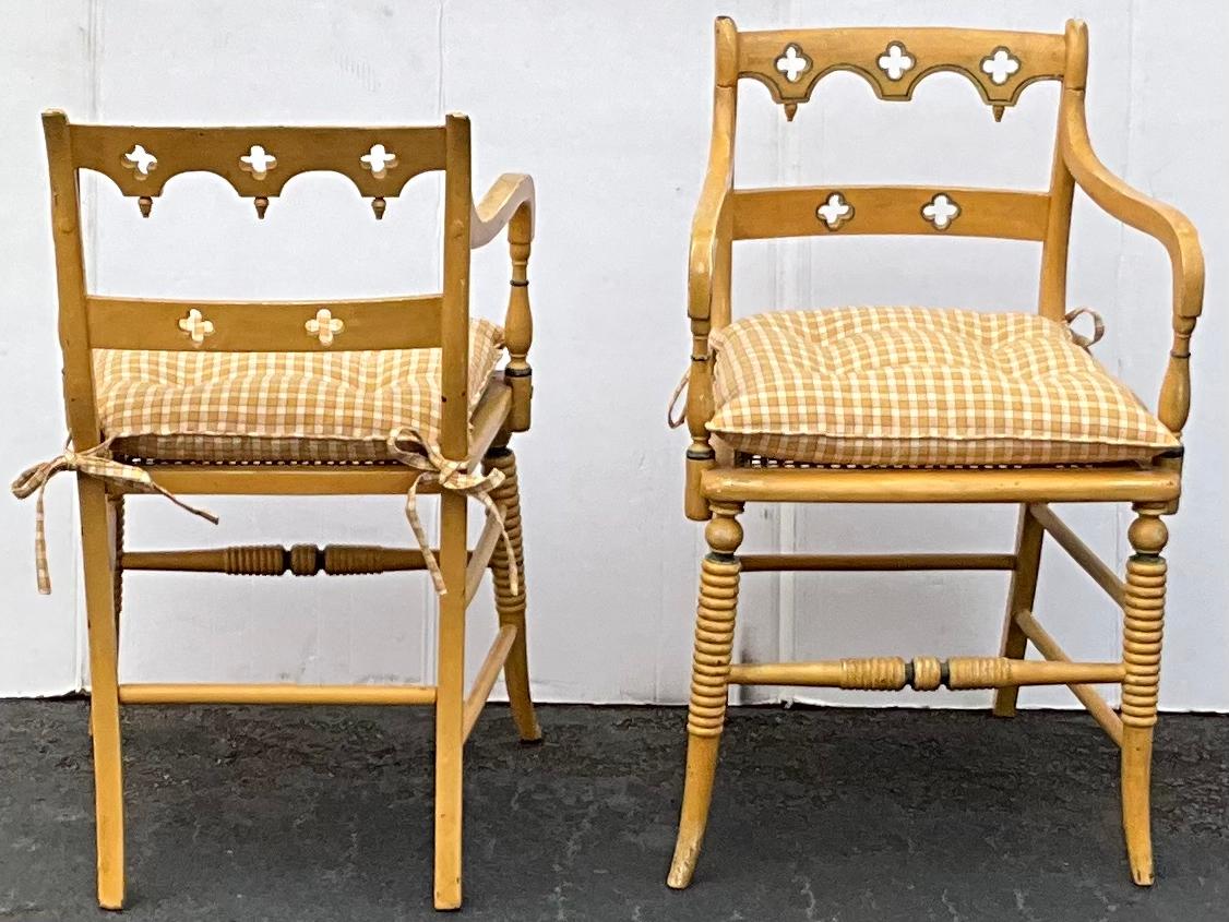 This is a pair of early 20th century hand painted and carved English Regency style chairs. They are sort of a soft gold and have a check cushion that is attached. The vintage upholstery is in very good condition. The frames have a general age wear.