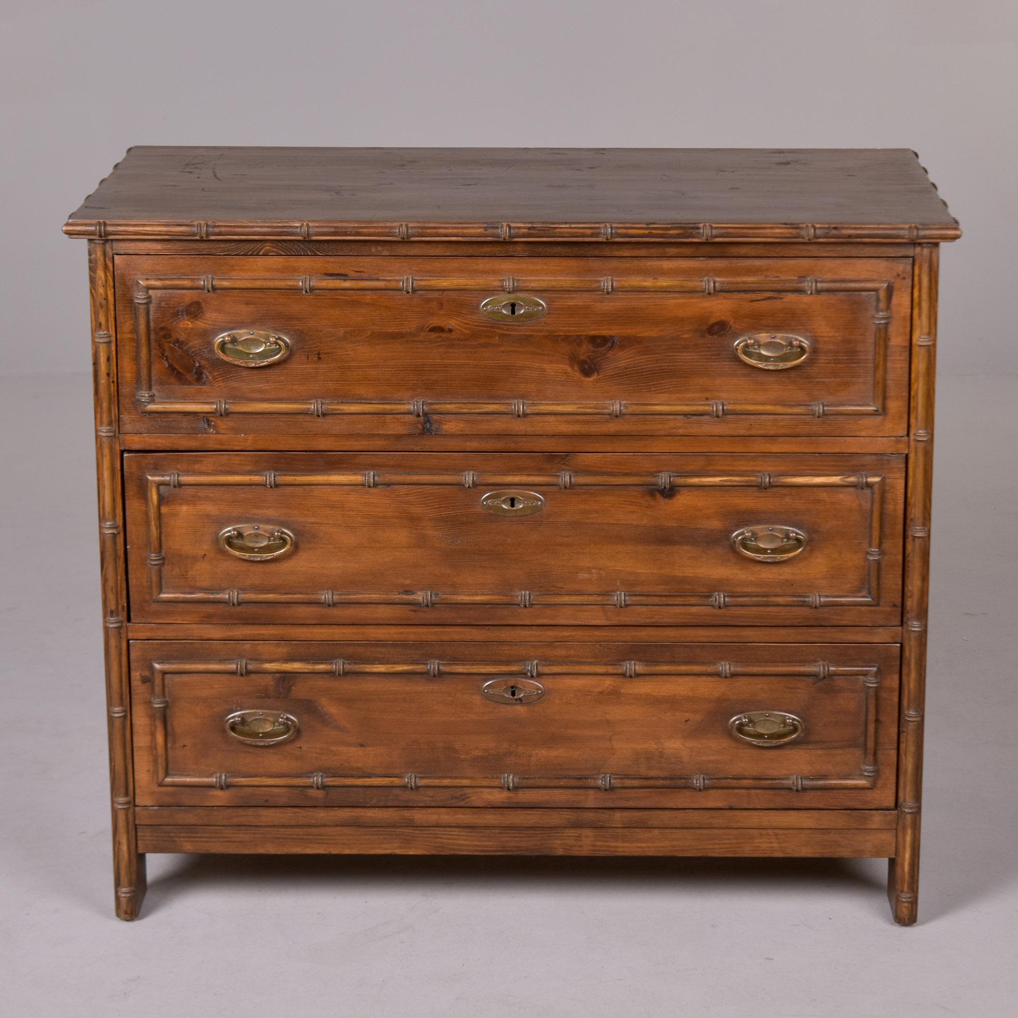 Circa 1920s chest of three drawers found in England. Not sure of wood type - appears to be pine with stained veneer and bamboo trim. Brass pulls and escutcheons. Solid structurally with dovetail construction on drawers. Unknown maker. Practical and