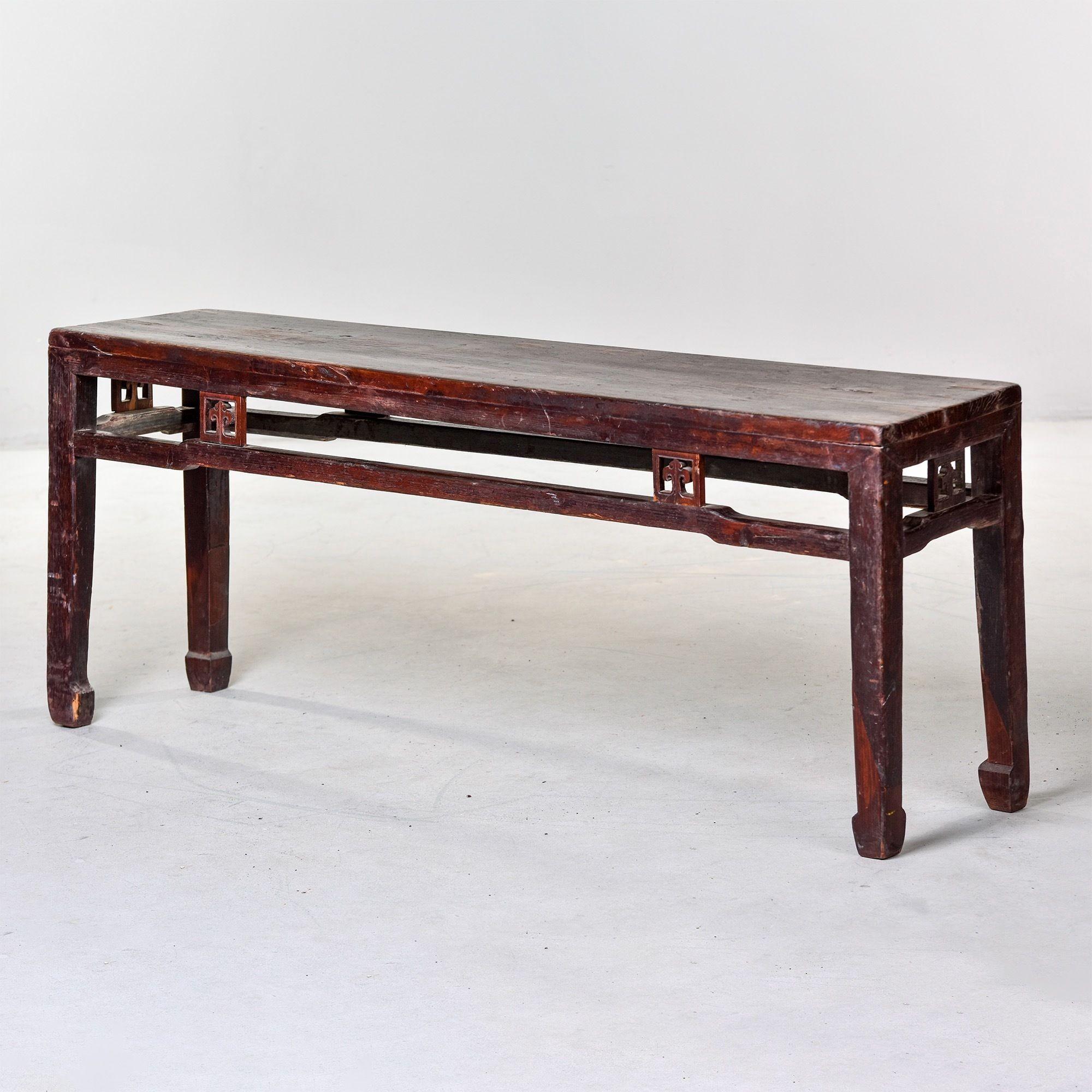 Circa 1900 long narrow Chinese elm wood bench from the Dong Yang region. Original finish shows great color, patina and wear. Open work carved details on the apron and sides. Very sturdy. Unknown maker.