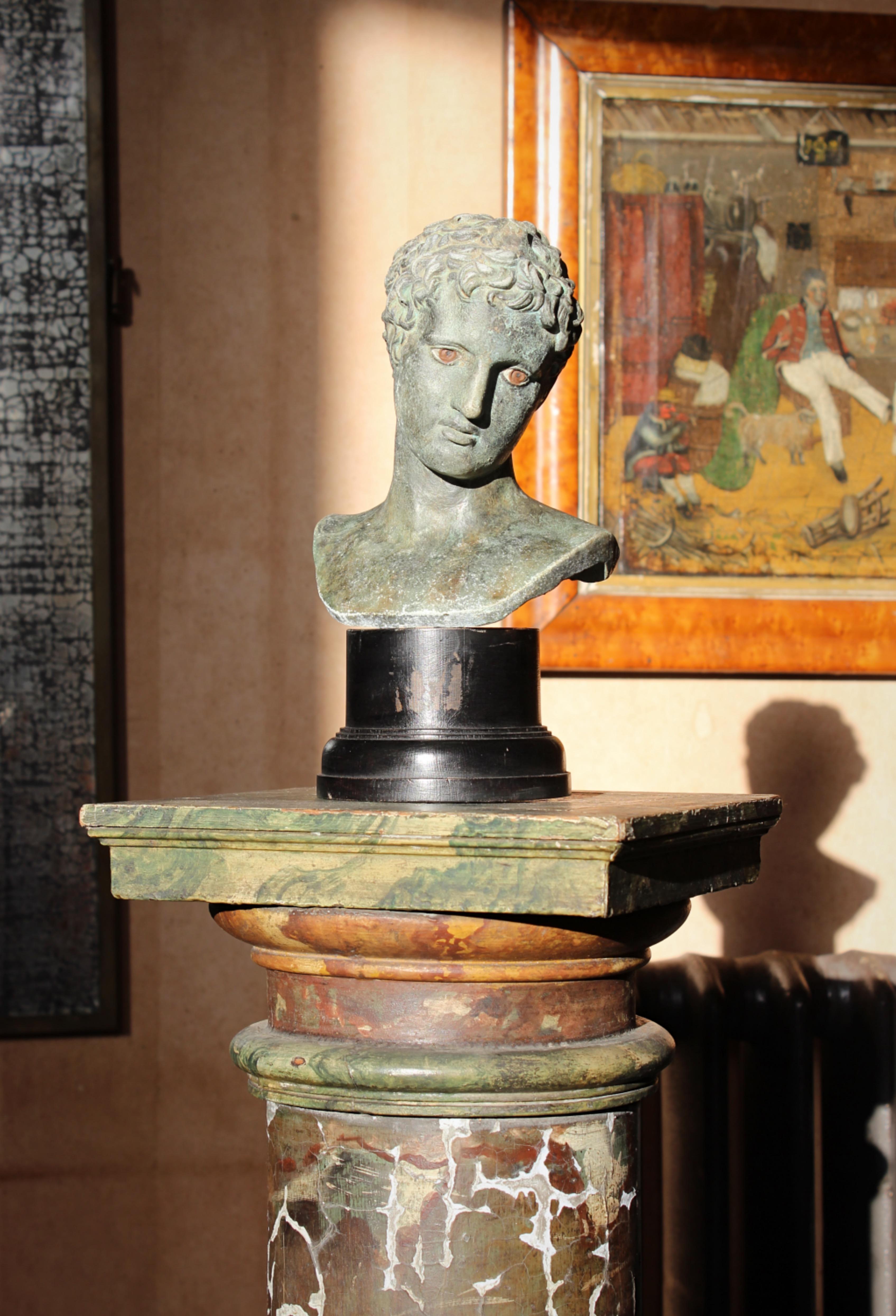 After the antique bust of David, plaster with a faux painted bronze & verdigris finish. Mounted on a well turned and ebonised plinth.

Second quarter of the 20th century in age 

30cm in height 
16cm in width 
12cm in depth 