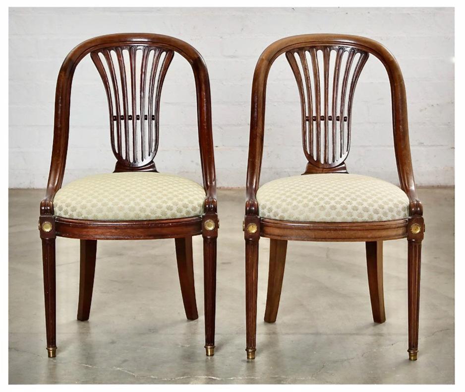 This is a great set of 8 French Empire-style gondola chairs in walnut. The slatted backs combined with the gondola form of these chairs very chic. All 8 chairs are in overall good condition. Two of the chairs have minor shrinkage cracks which do not