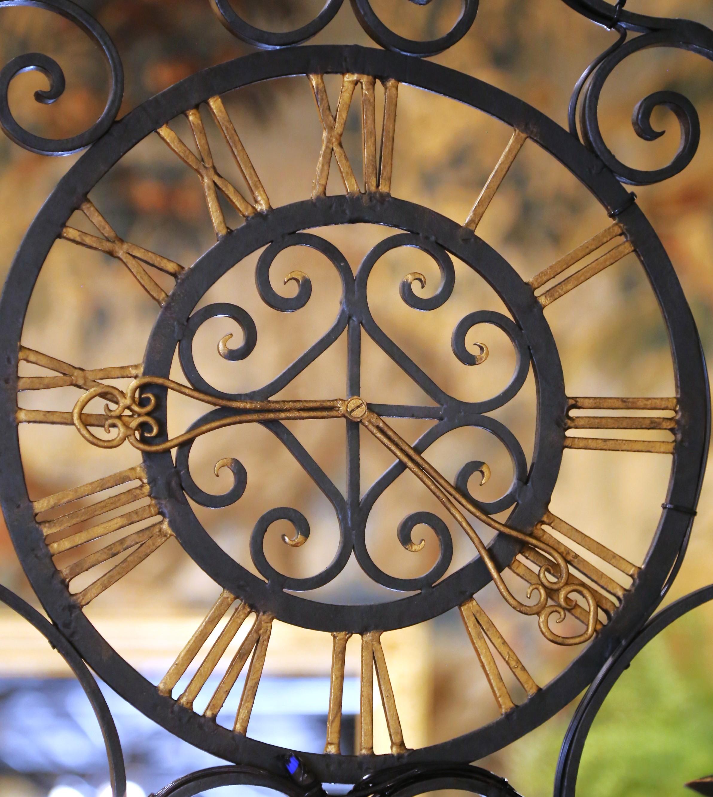 Francese Lampadario a forma di quadrante di orologio in ferro battuto dipinto di verde e dorato, risalente ai primi anni del XX secolo. in vendita