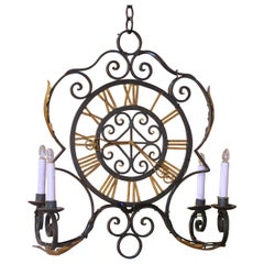 Lampadario a forma di quadrante di orologio in ferro battuto dipinto di verde e dorato, risalente ai primi anni del XX secolo.