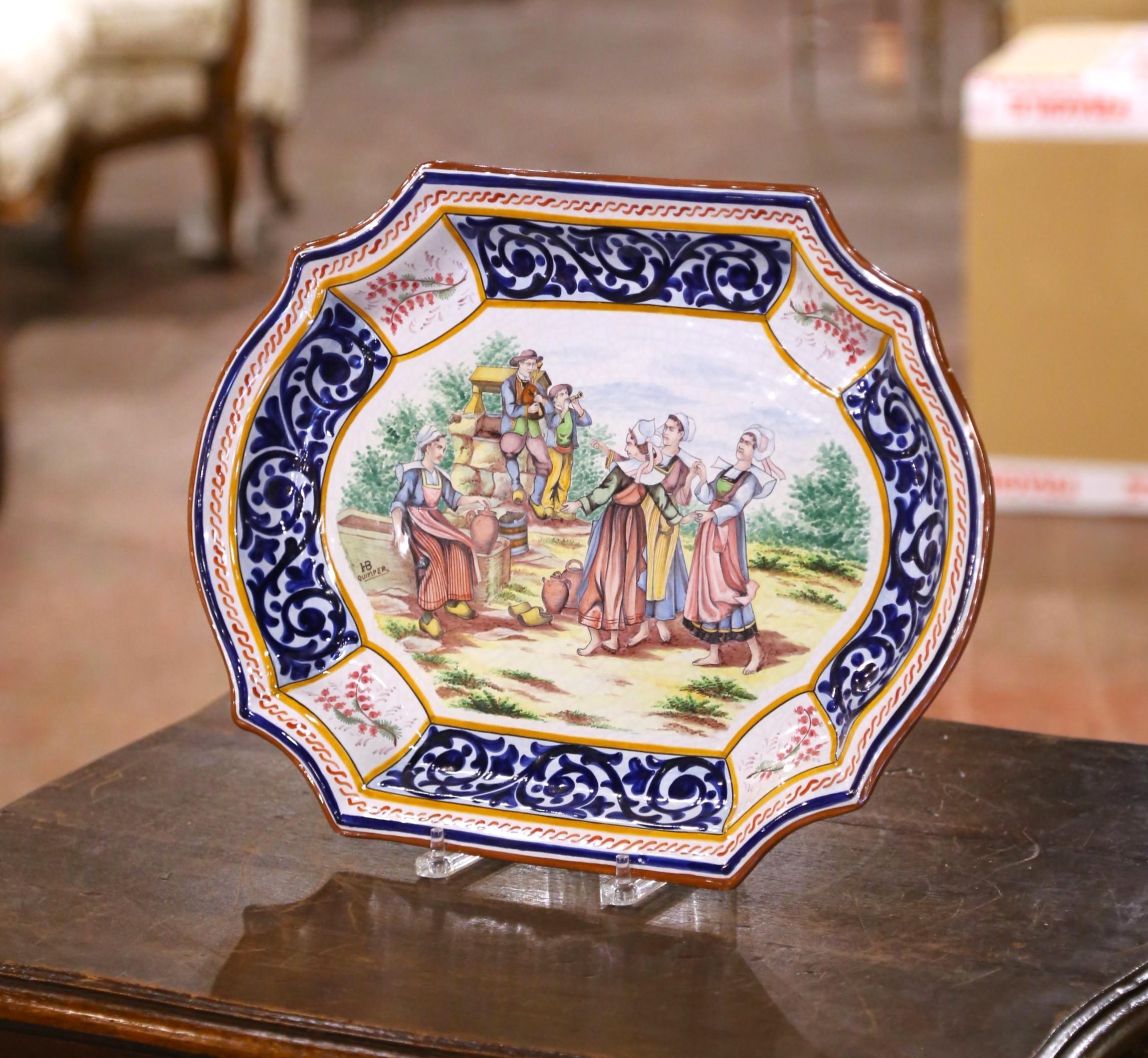 Colorful French faience platter by HB Quimper, crafted in the early 20th century and measuring 18 inches wide by 13 inches high. This hand-painted earthenware piece features a shaped octagonal form with a bold border of scrolling cobalt blue motifs