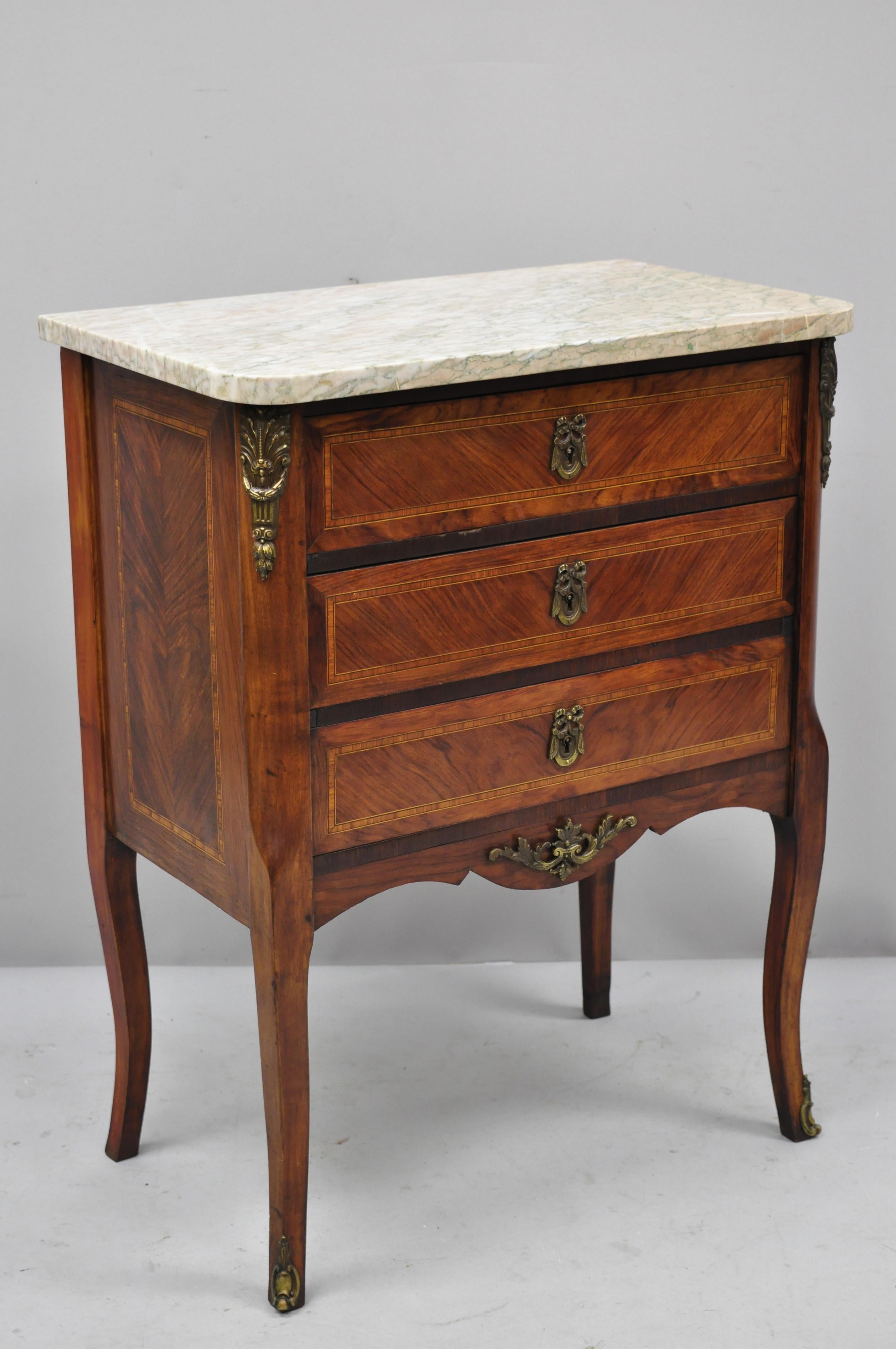 Early 20th century French Louis XV marble-top nightstand with bronze ormolu. Item features marble top, kingwood inlay, bronze ormolu, beautiful wood grain, no key, but unlocked, 3 dovetailed drawers, cabriole legs, very nice antique item, great