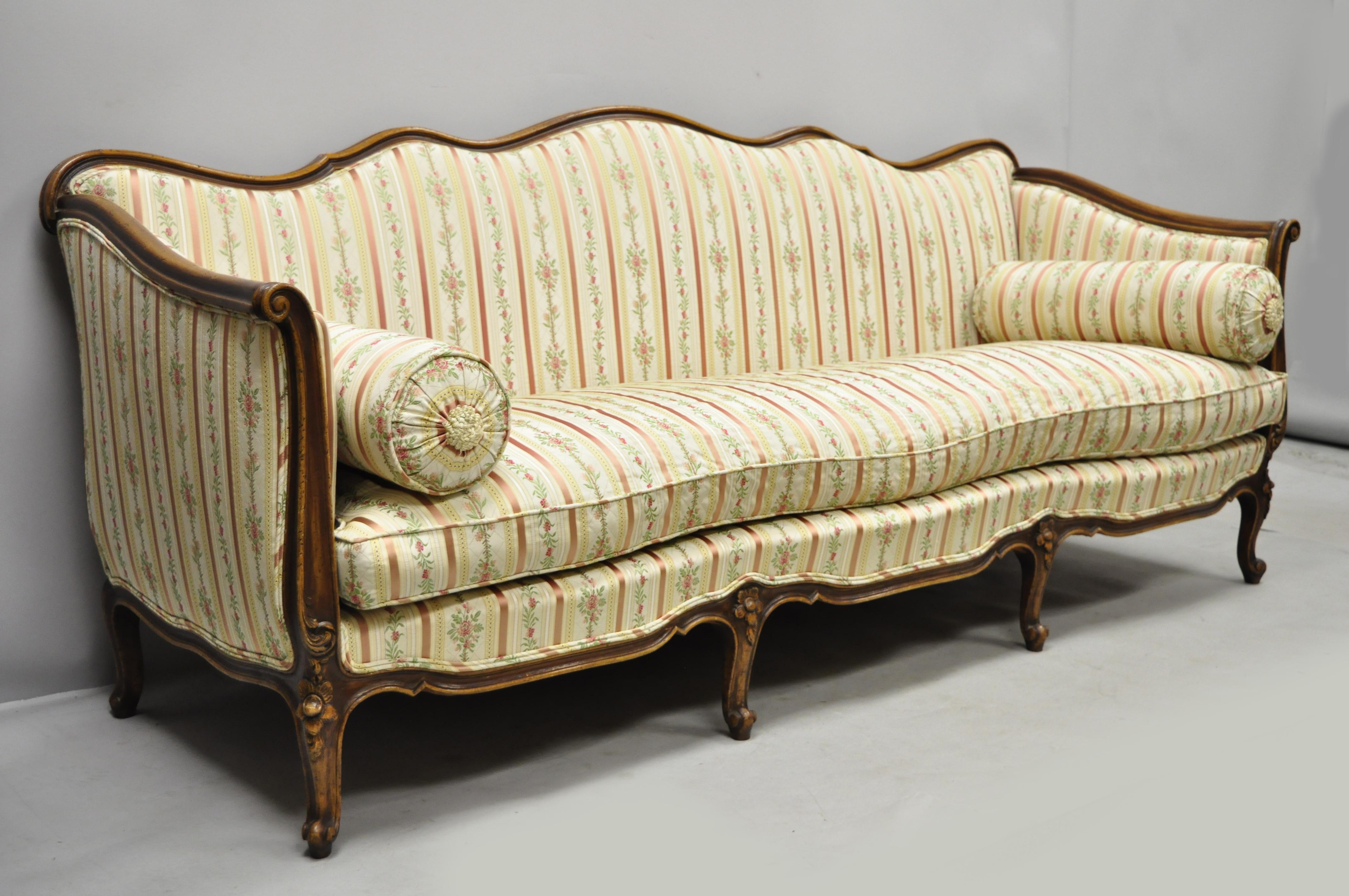 Early 20th century French Louis XV Provincial style sofa with serpentine carved back originally sold by W & J Sloane. Made in Italy. Item features serpentine carved rails, pink striped silk upholstery, solid wood frame, beautiful wood grain,