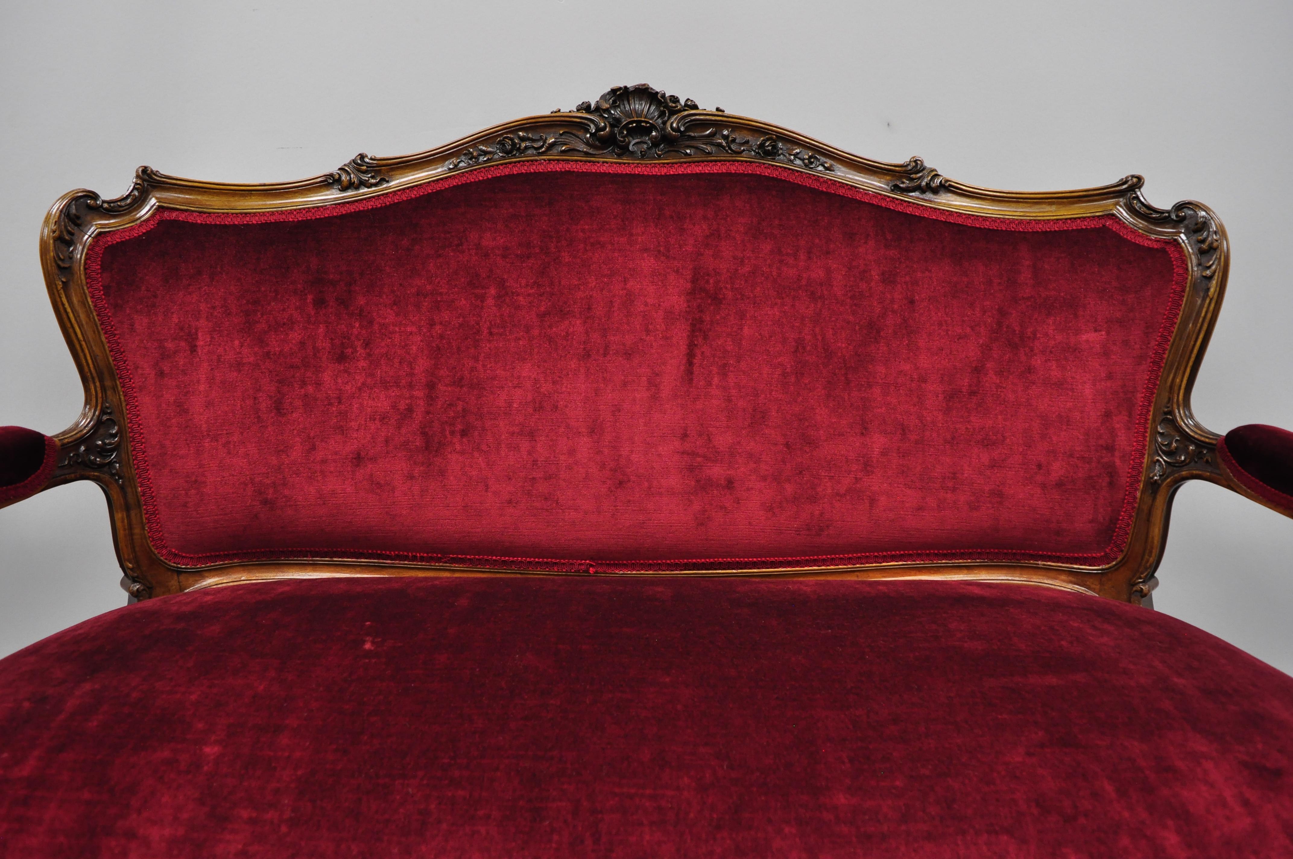 Early 20th century French Louis XV style shell carved mahogany sofa settee in red fabric. Item features shell carved top rail, solid wood construction, beautiful wood grain, upholstered armrests, cabriole legs, very nice antique item, circa early