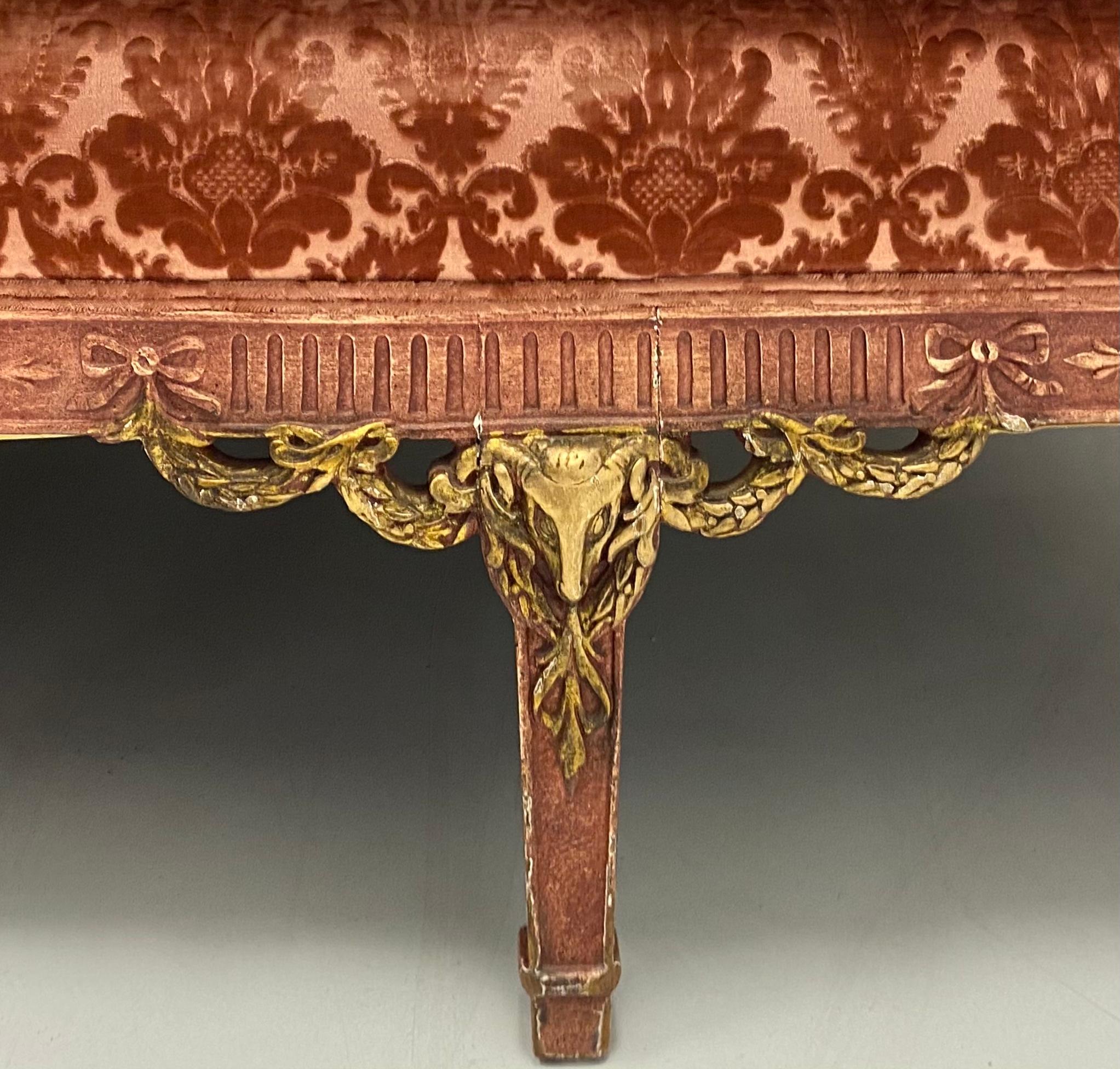 This is an early French neoclassical style pink velvet sofa or canapé . This is an amazing piece. Yes, it does show wear, but it is completely original. The pink painted frame is accentuated with gilt rams, and the cut pink velvet does not have any