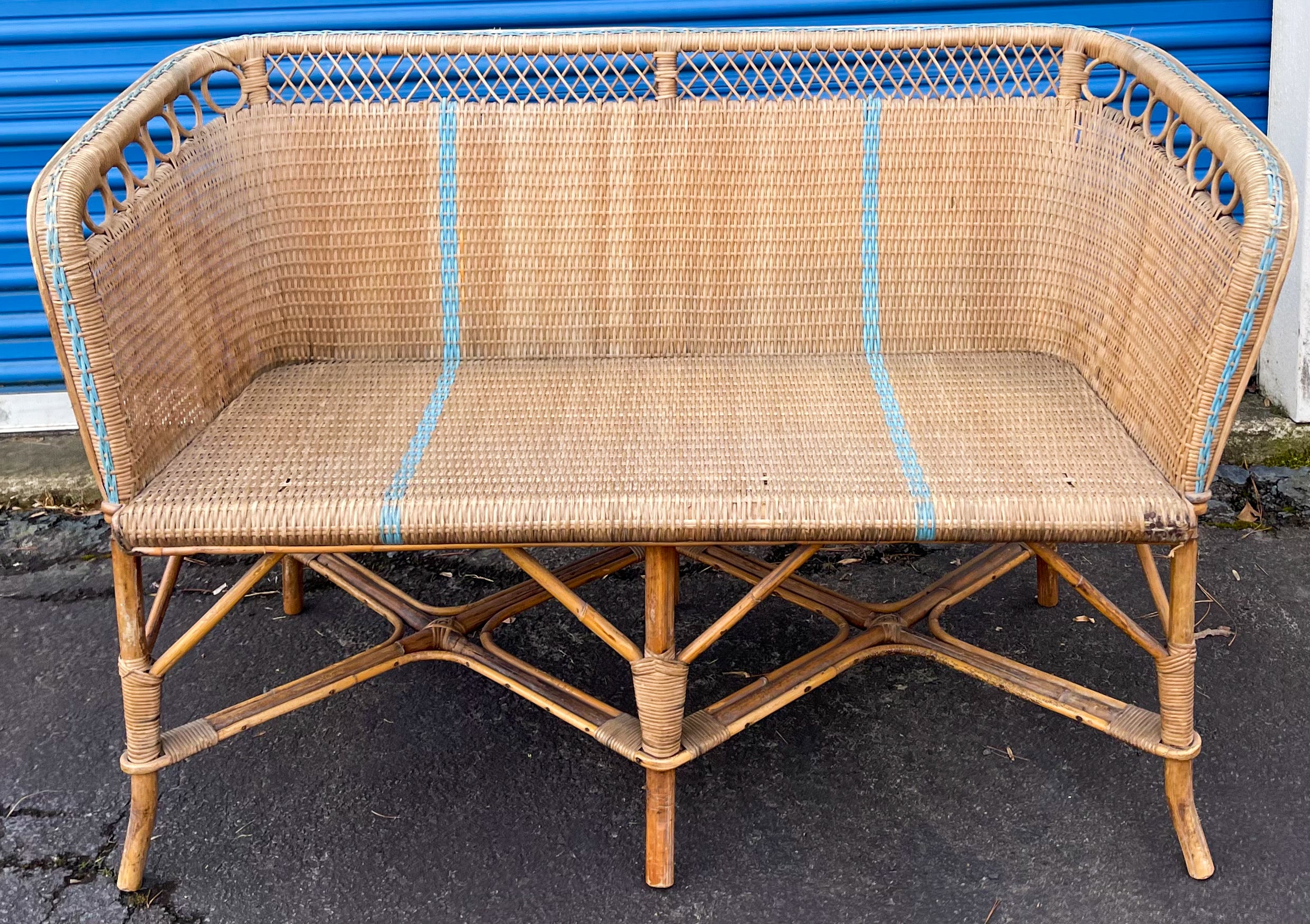 This is a really lovely French wicker and bamboo settee with blue painted stripe detail. Note the circling detail on the frame! It is in very good condition.