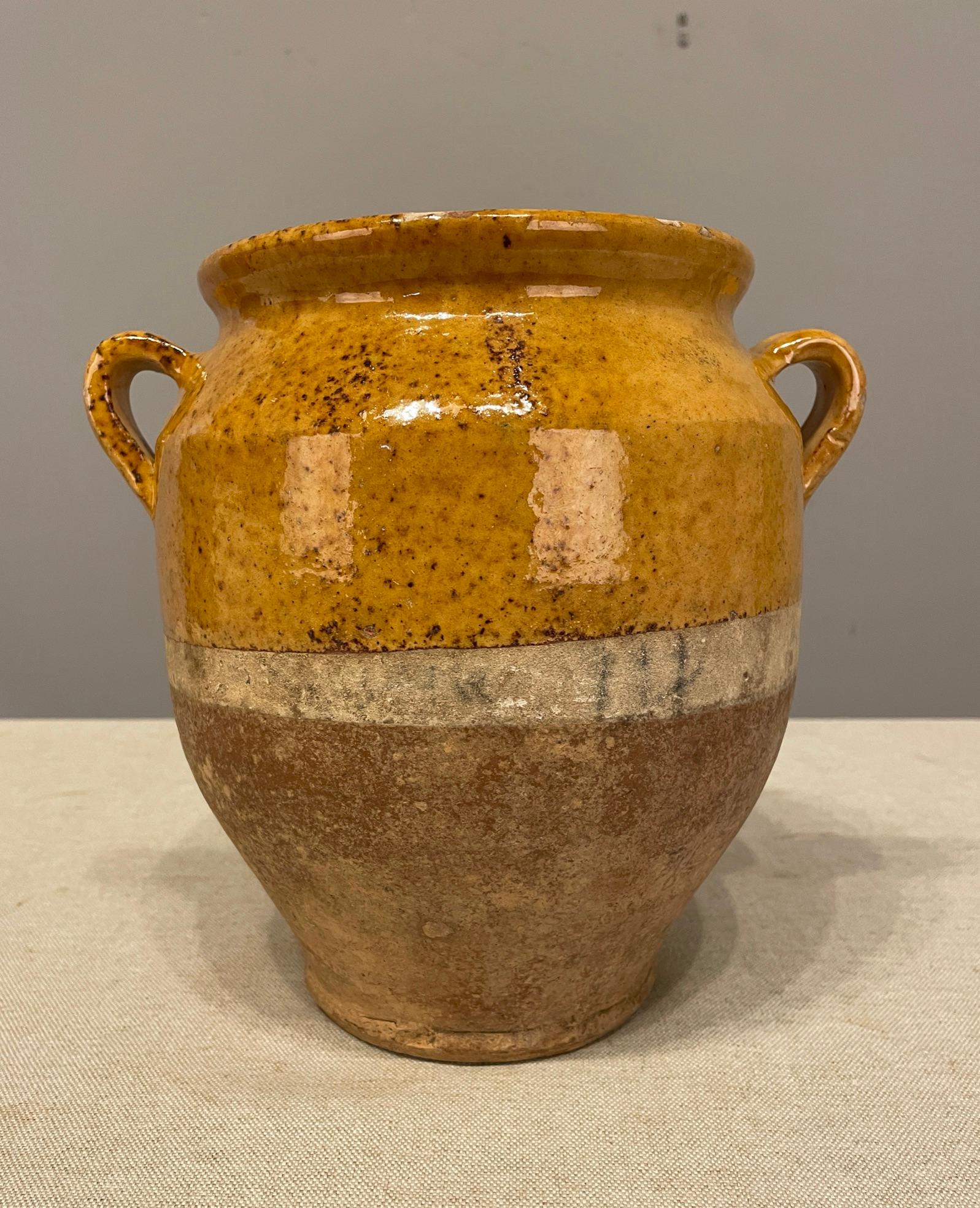 An earthenware confit pot from the Southwest of France with traditional yellow, ochre glaze. Some chips and losses to glaze. These ordinary earthenware vessels were once used daily in the French country home and have beautiful rustic glazes of