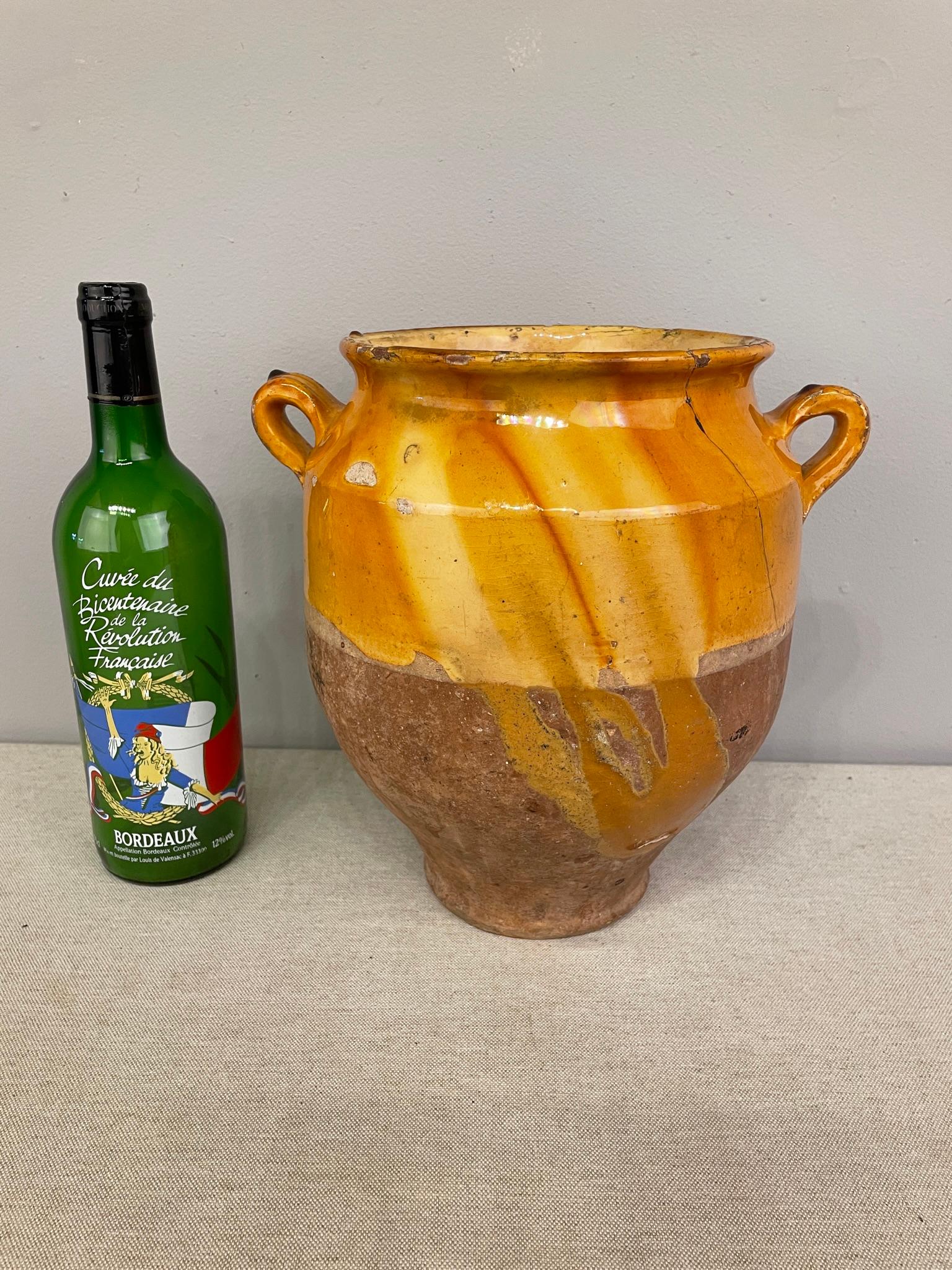 An earthenware confit pot from the Southwest of France with traditional yellow, ochre glaze. Some chips and losses to glaze. These ordinary earthenware vessels were once used daily in the French country home and have beautiful rustic glazes of